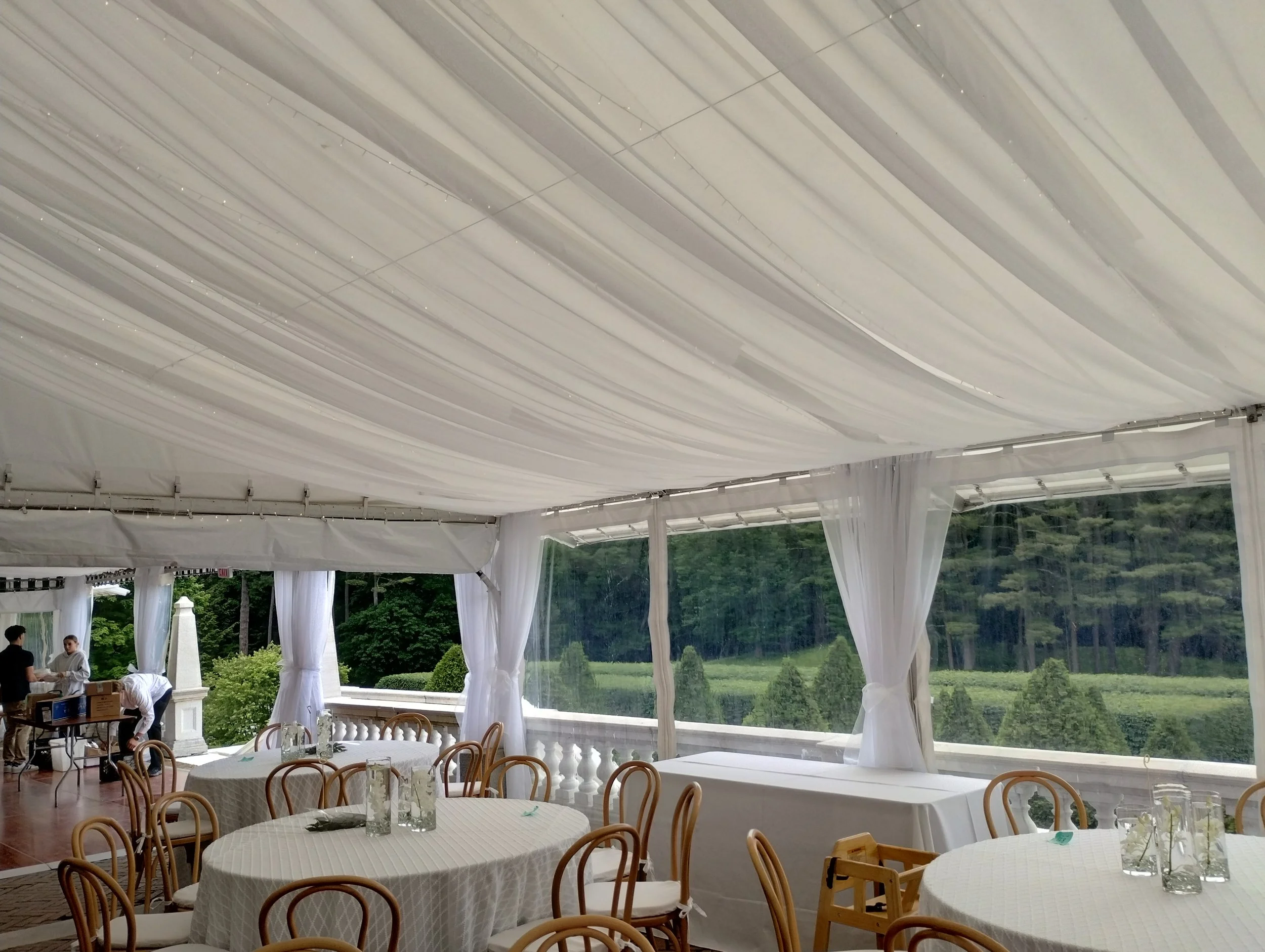 Sheer IRF Viole fabric draping installed by Berkshire Event Lighting covering the ceiling and all poles of covered terrace at The Mount in Lenox.