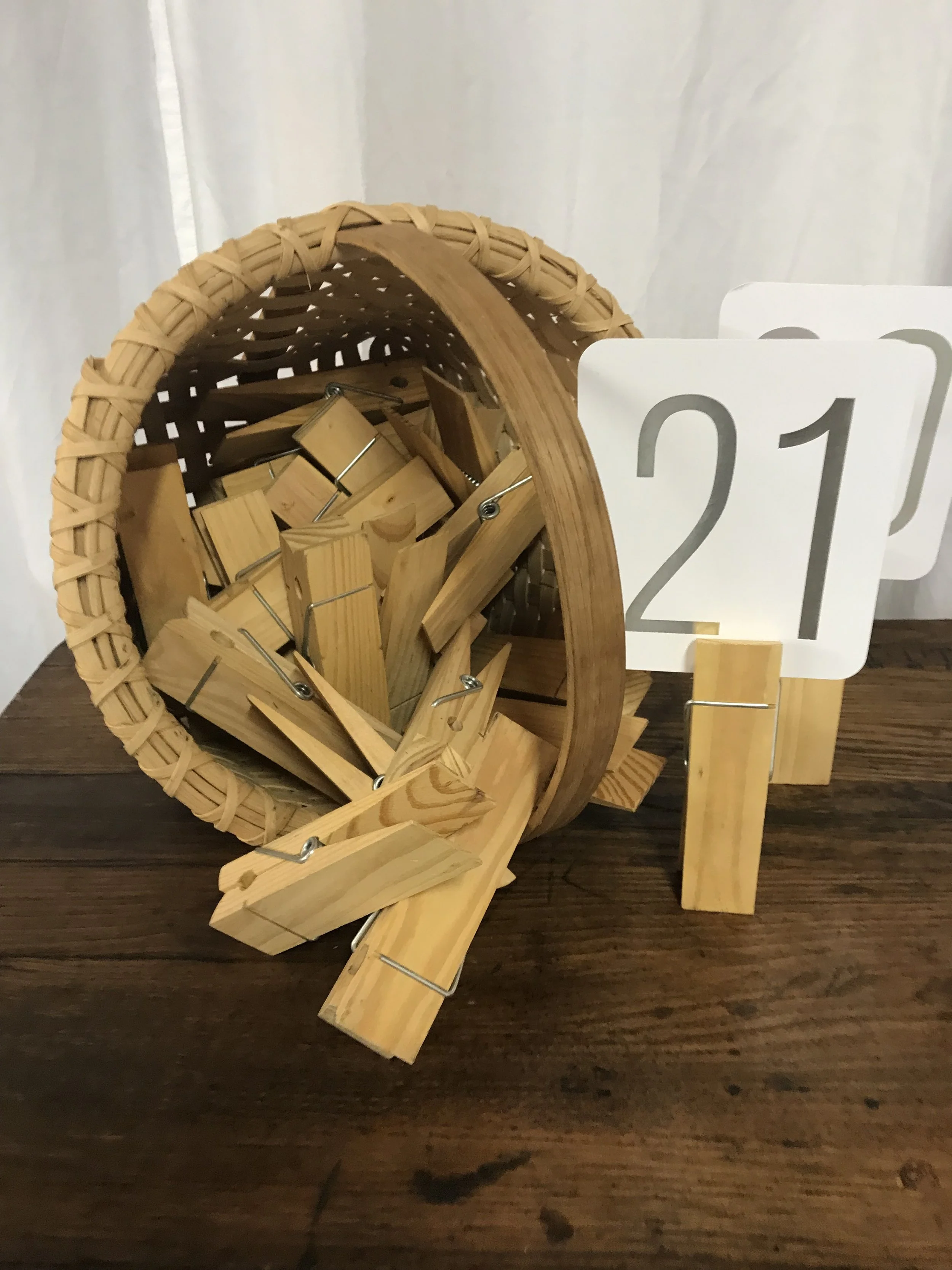 Large wooden clothespins used as rustic place card holders for wedding seating by Berkshire Event Lighting
