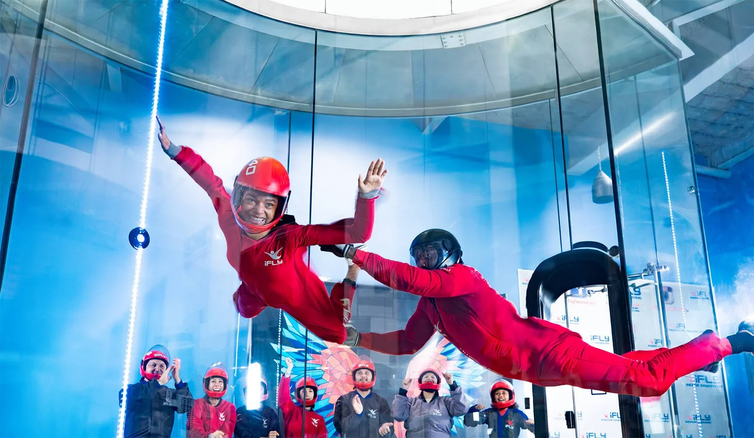 Smiling guest flying at iFLY with an instructor