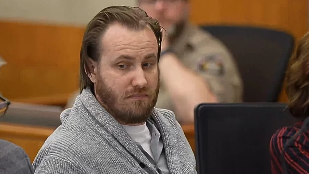 Man with beard and longer hair in sweater in court