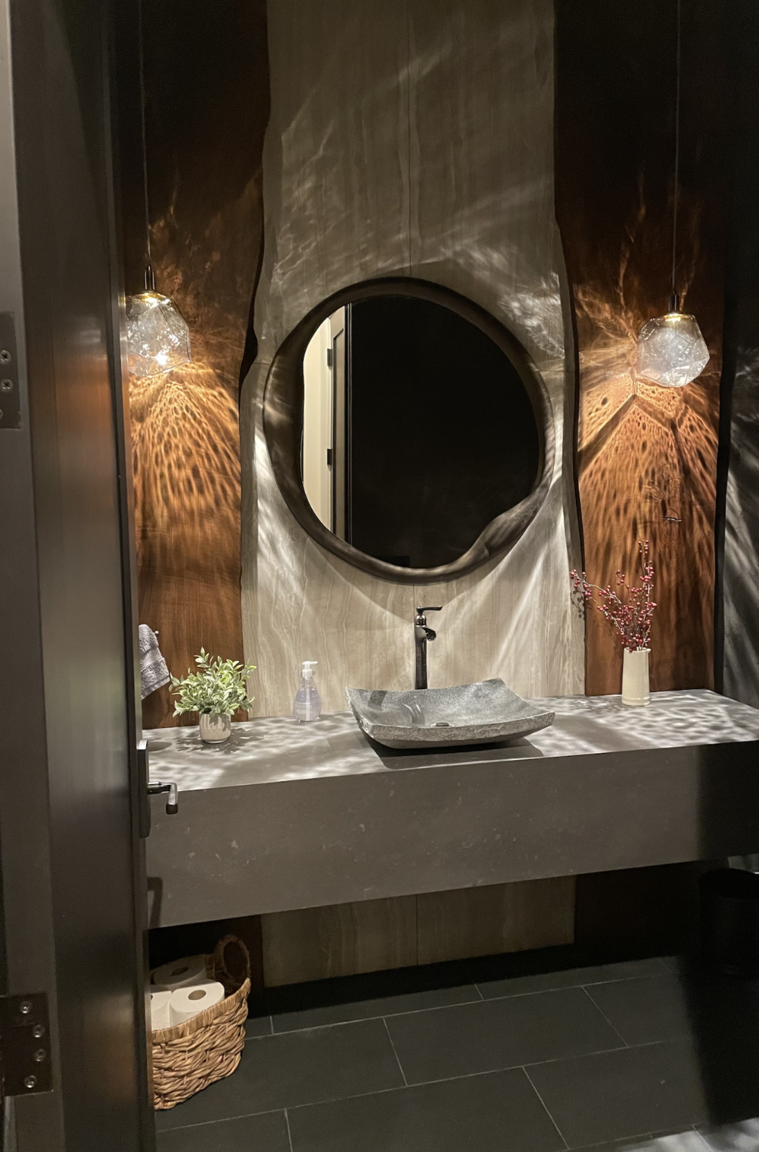 I wanted this powder bath to feel dark, moody, and connected to nature. I personally selected the live-edge wood slabs from California for their beautiful grain and organic contours, layering them over Italian marble to create depth and contrast. A s