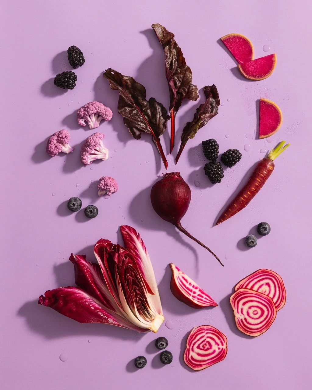 purple veggies beets chicory blackberries on purple background