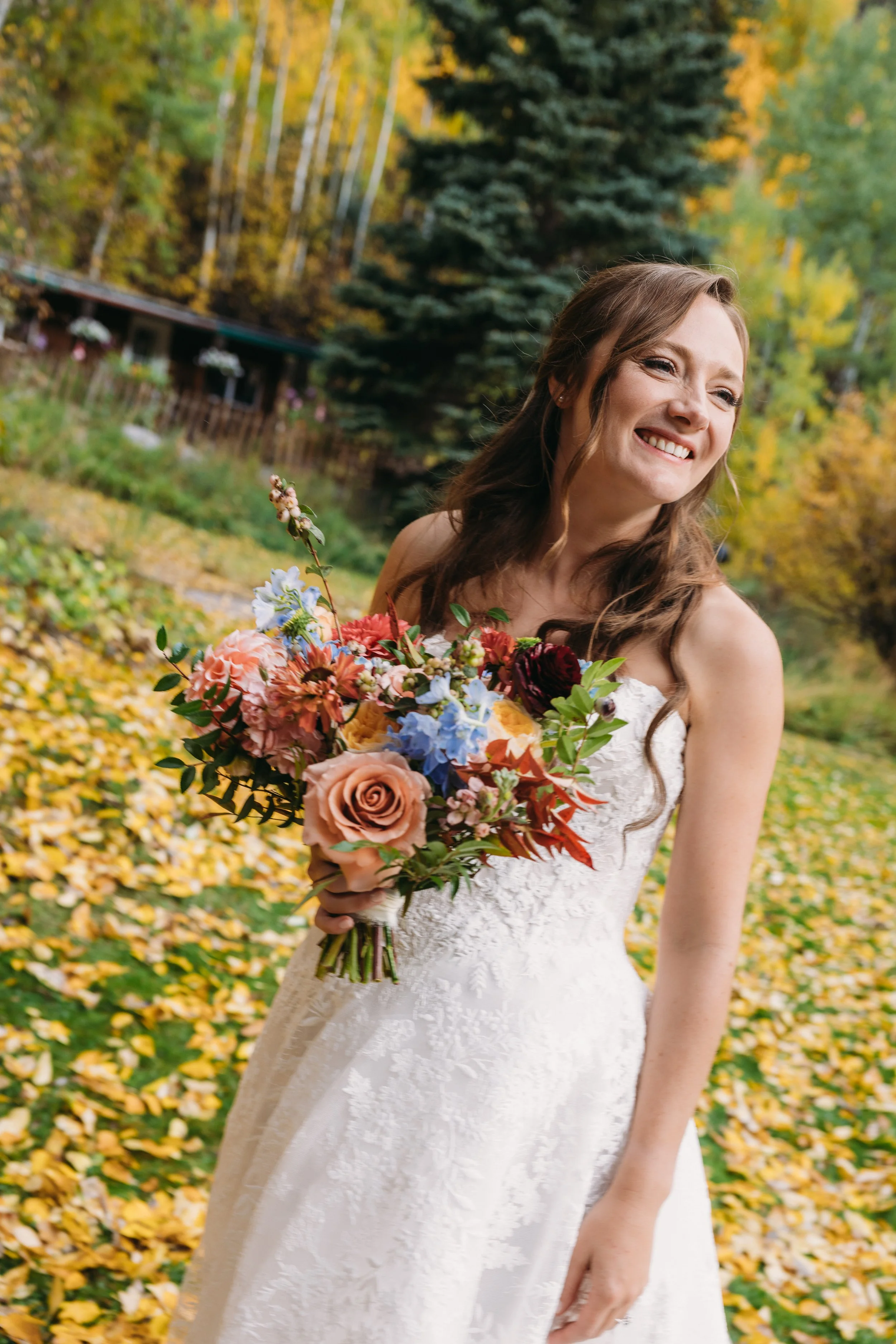 A beautiful Snowmass, Colorado bride wearing a romantic half-up bridal hairstyle with seamless hair extensions. Soft waves and added volume created an elegant, timeless look perfect for her mountain wedding, showcasing luxury bridal hair styling in A
