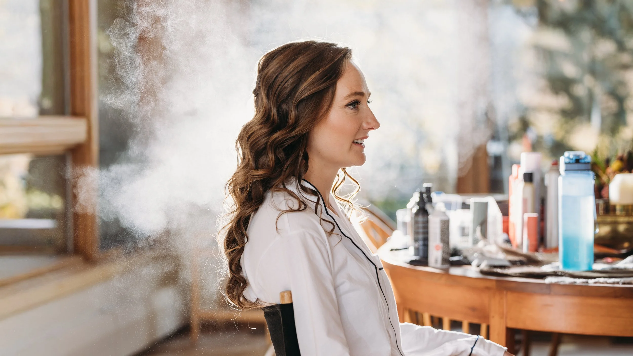 A beautiful Snowmass, Colorado bride wearing a romantic half-up bridal hairstyle with seamless hair extensions. Soft waves and added volume created an elegant, timeless look perfect for her mountain wedding, showcasing luxury bridal hair styling in A