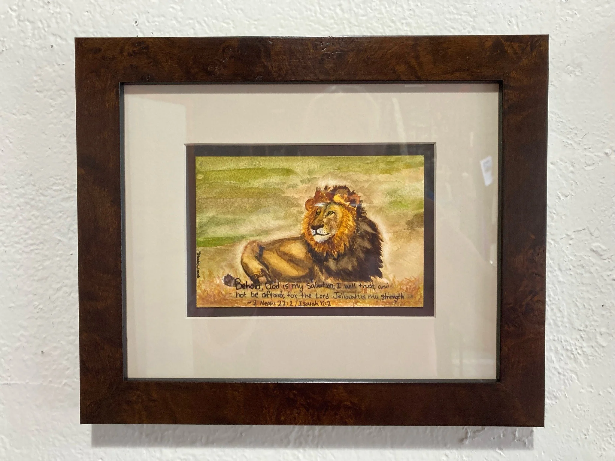 Small artwork doesn’t always mean a small statement! This little lion card was transformed with a rich brown inner mat and a burl wood frame that highlight the warmth, texture, and strength of the image. The creamy top mat brings out the subtle backg