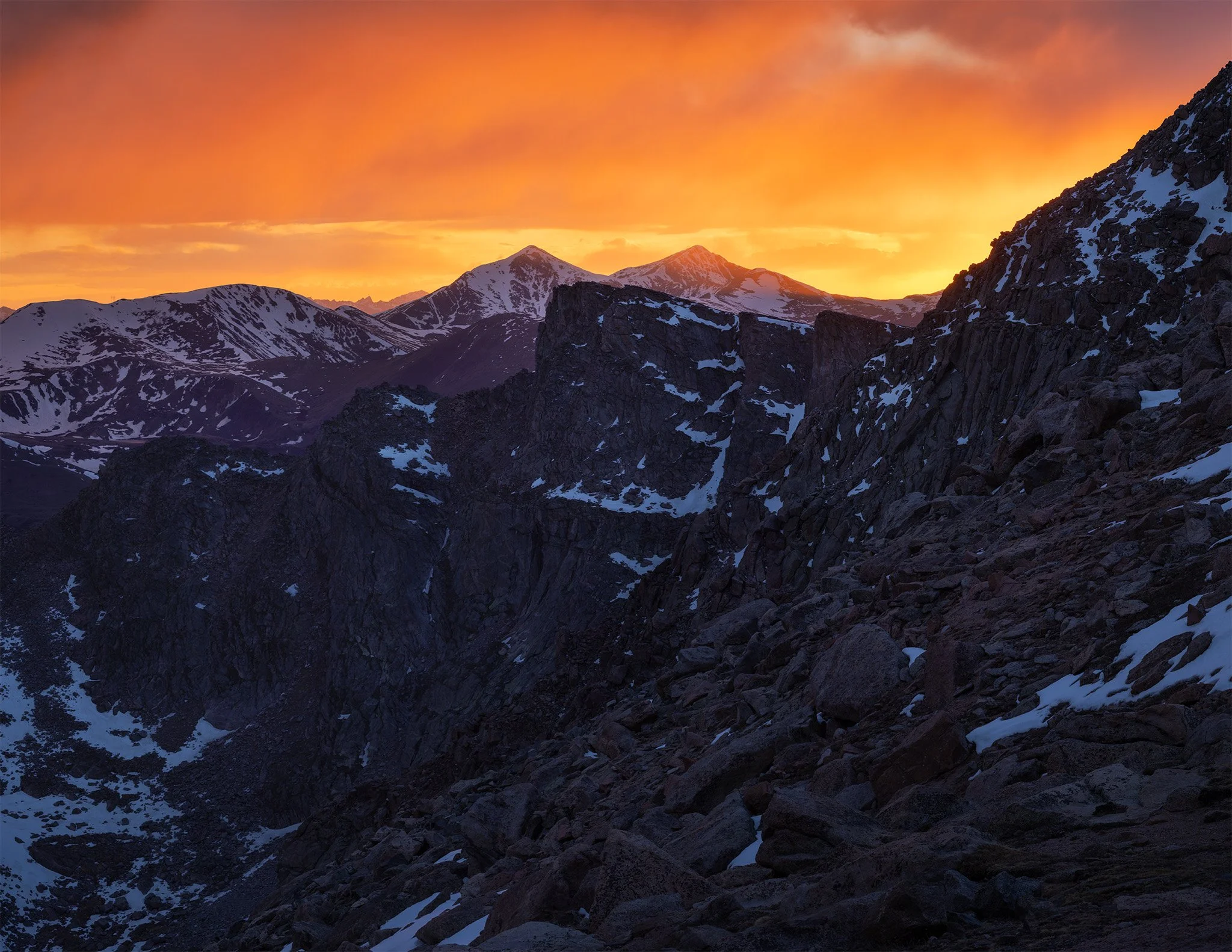 Orange sunset sky over Grays and Torreys Peaks from the Mount Blue Sky road, Front Range, Colorado.