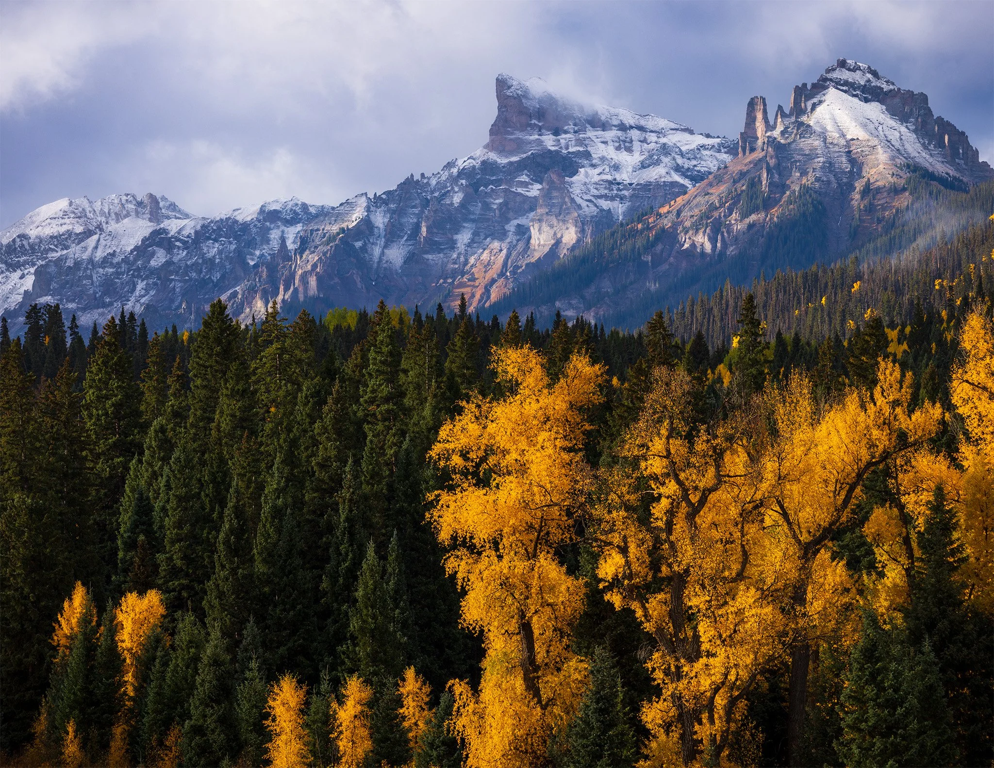 Golden cottonwoods below fresh snow on Chimney Rock and Courthouse Mountain, San Juan Mountains, Colorado.