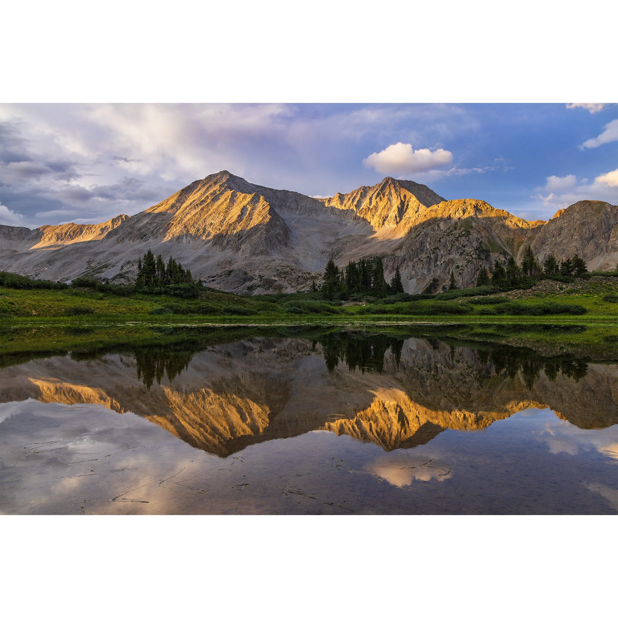 Evening light on Snowmass Mountain reflected in a high alpine tarn, Maroon Bells-Snowmass Wilderness, Colorado
