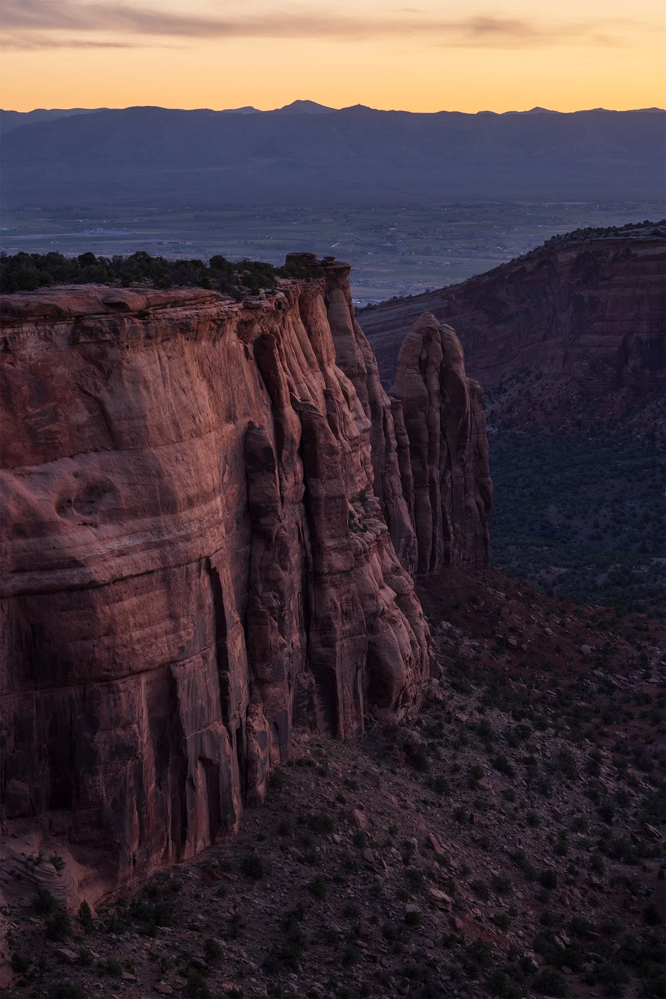 Sunrise over red sandstone cliffs and monoliths above the Grand Valley, Colorado National Monument, Colorado.