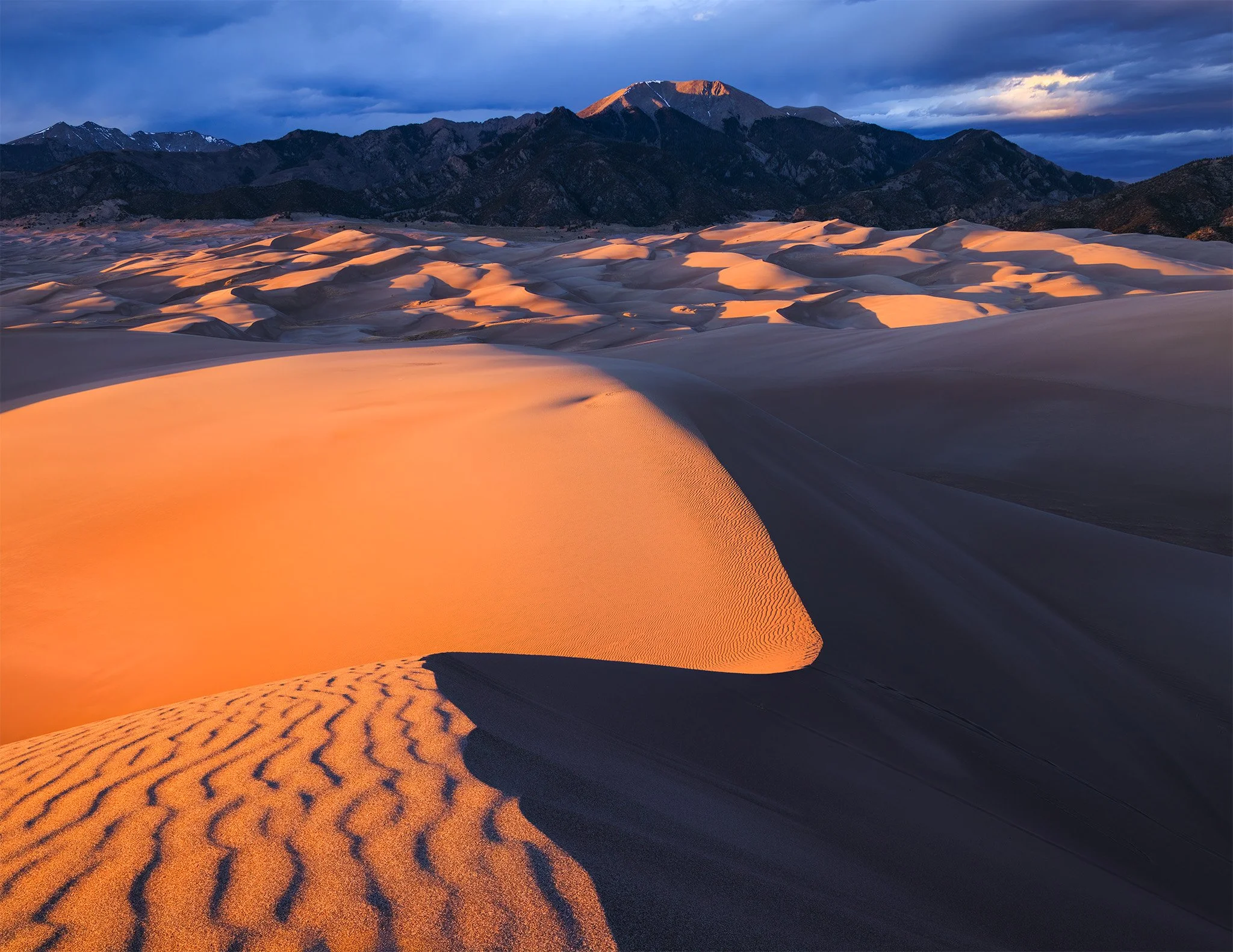 Sunrise light on the dunes at Great Sand Dunes National Park below the snowless Sangre de Cristo Mountains, Colorado.