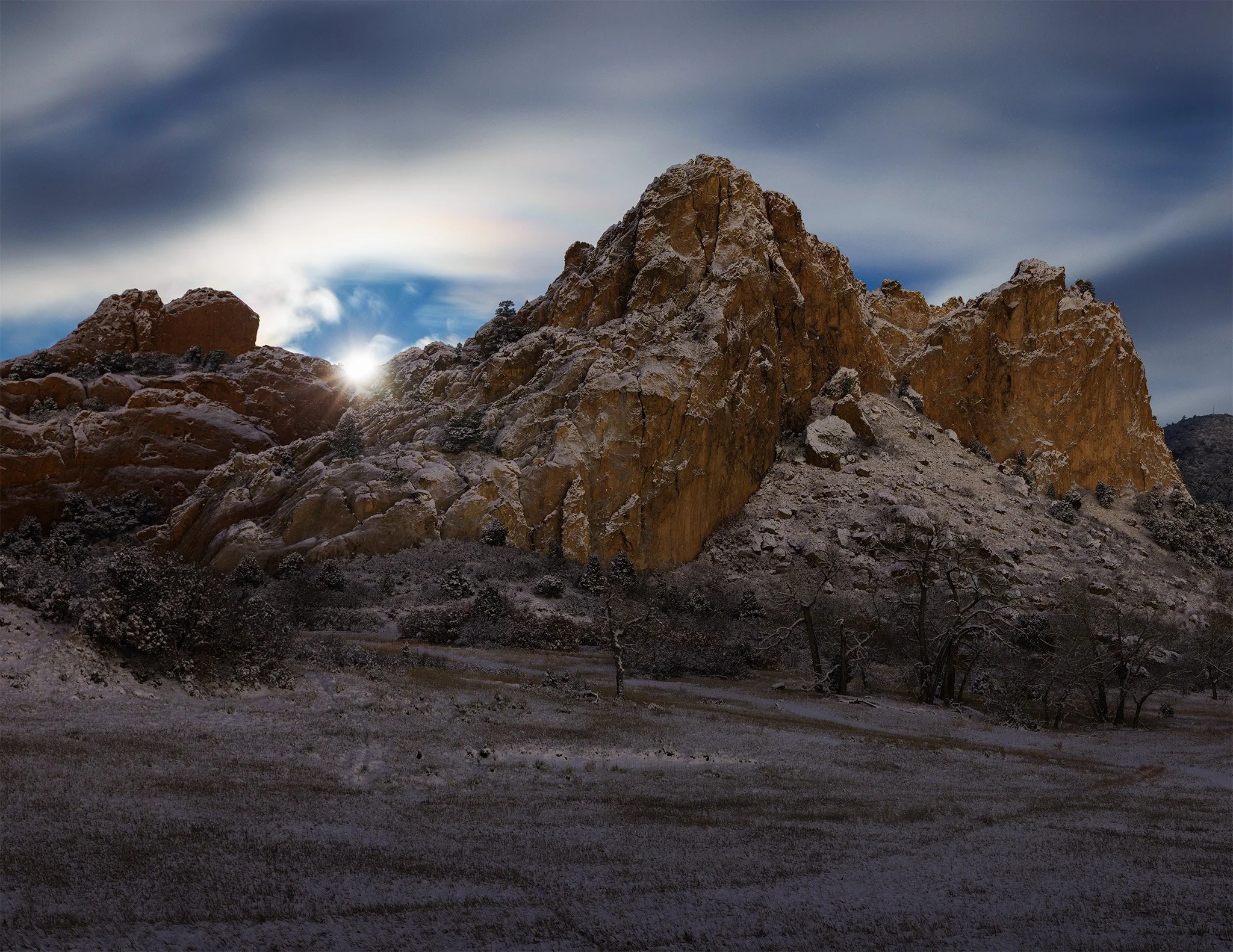 Moonset over snow-covered red rock at Garden of the Gods before dawn, Colorado Springs, Colorado.