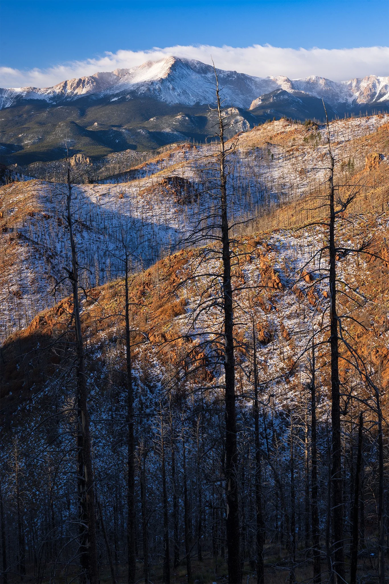 First light on a snow-dusted burn scar below Pikes Peak, Colorado Springs, Colorado.