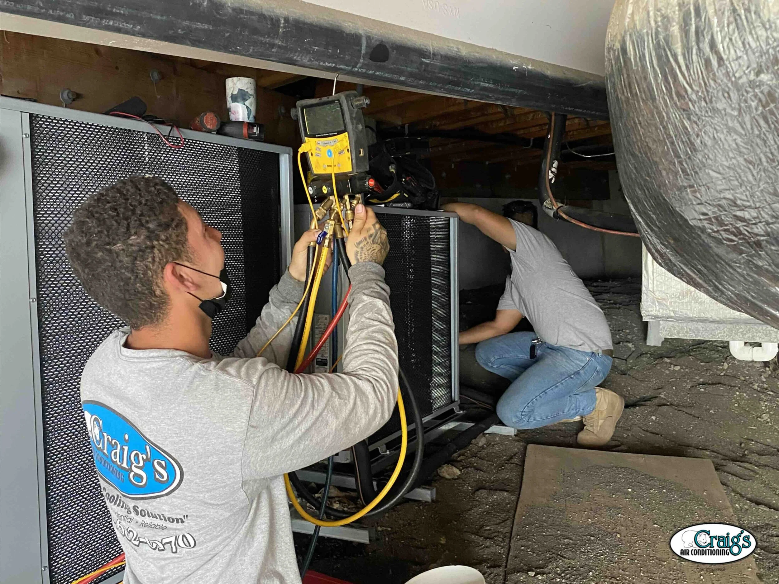 technician performing maintenance on air conditioner using manifold tool