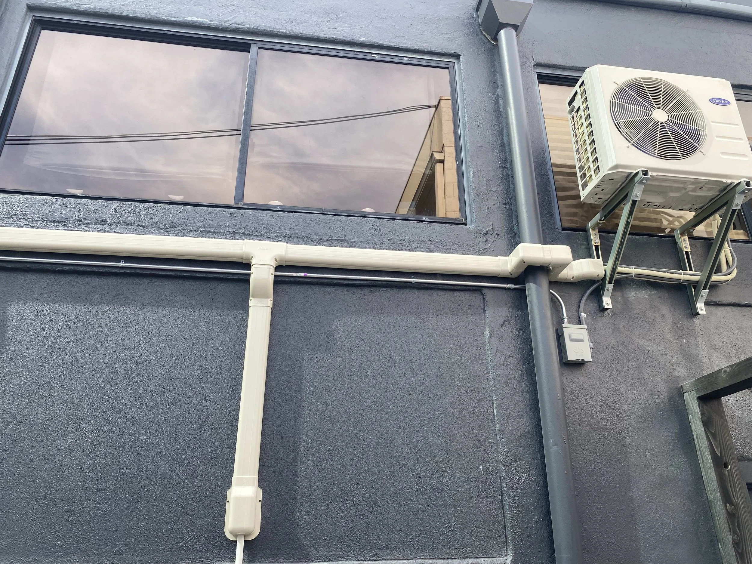 Completed AC piping installation on building's side