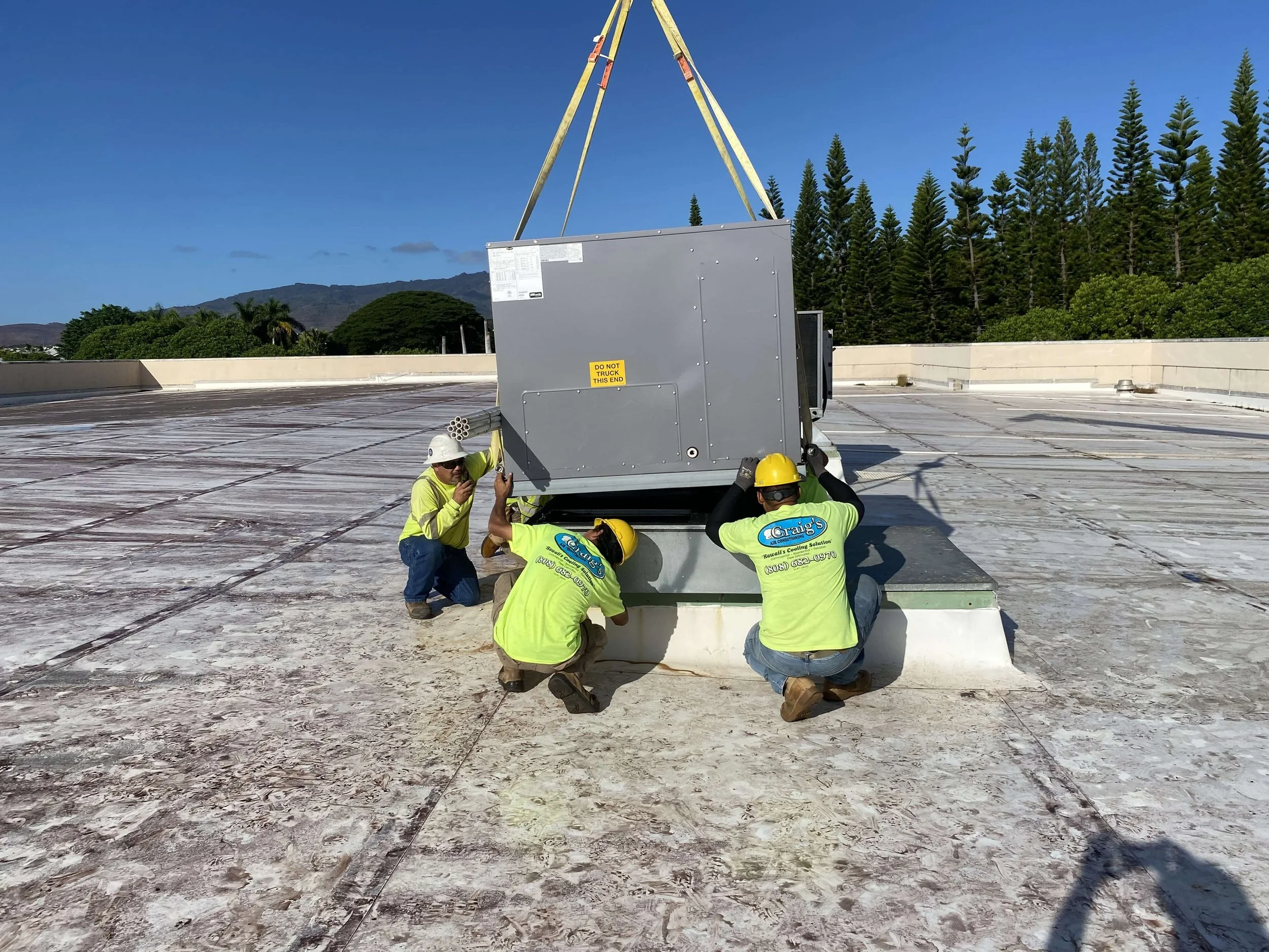 A new HVAC unit being positioned on a rooftop by HVAC professionals, November 2022.
