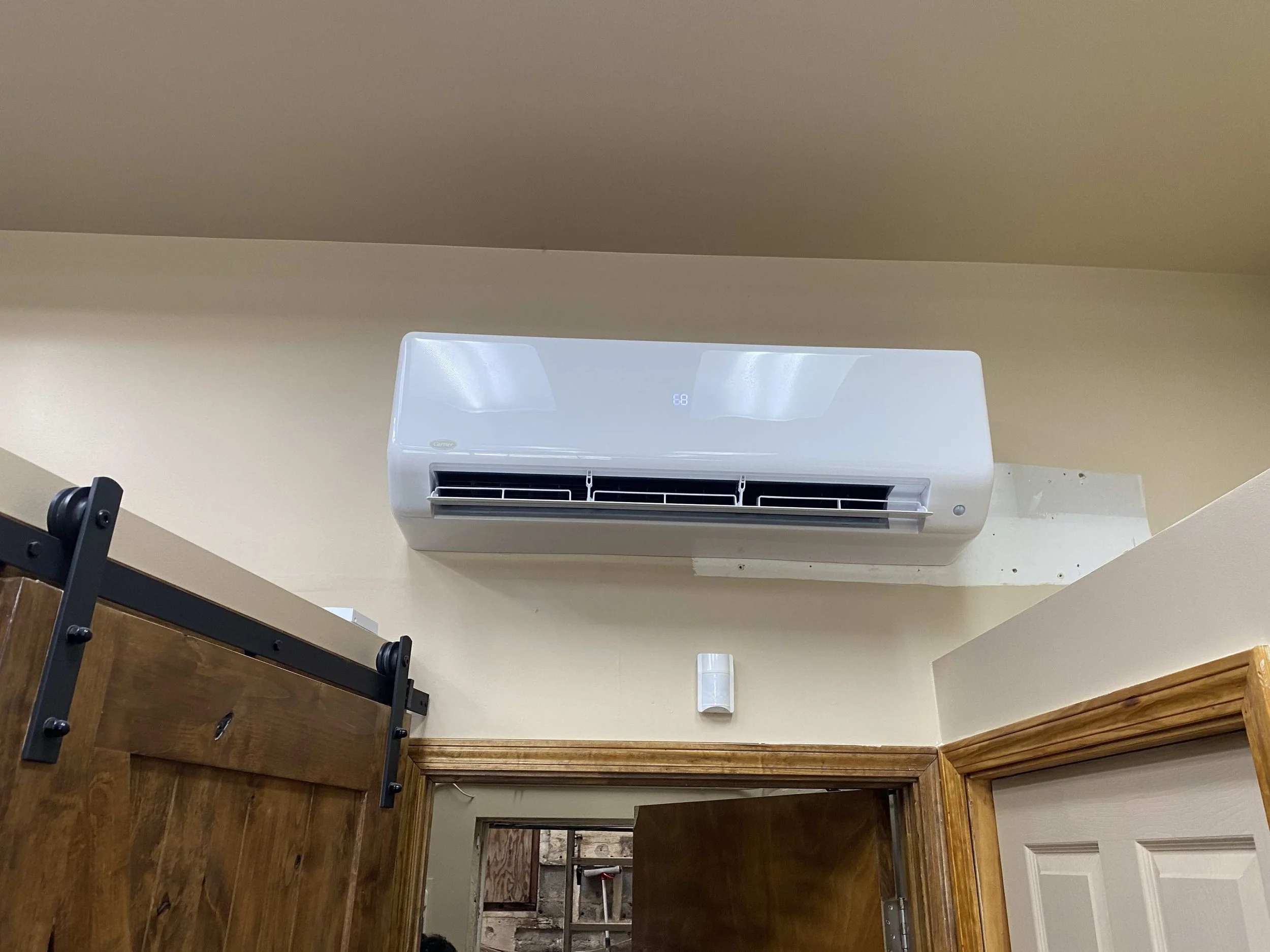 Indoor HVAC unit installed above the doorway, connected to the outdoor system