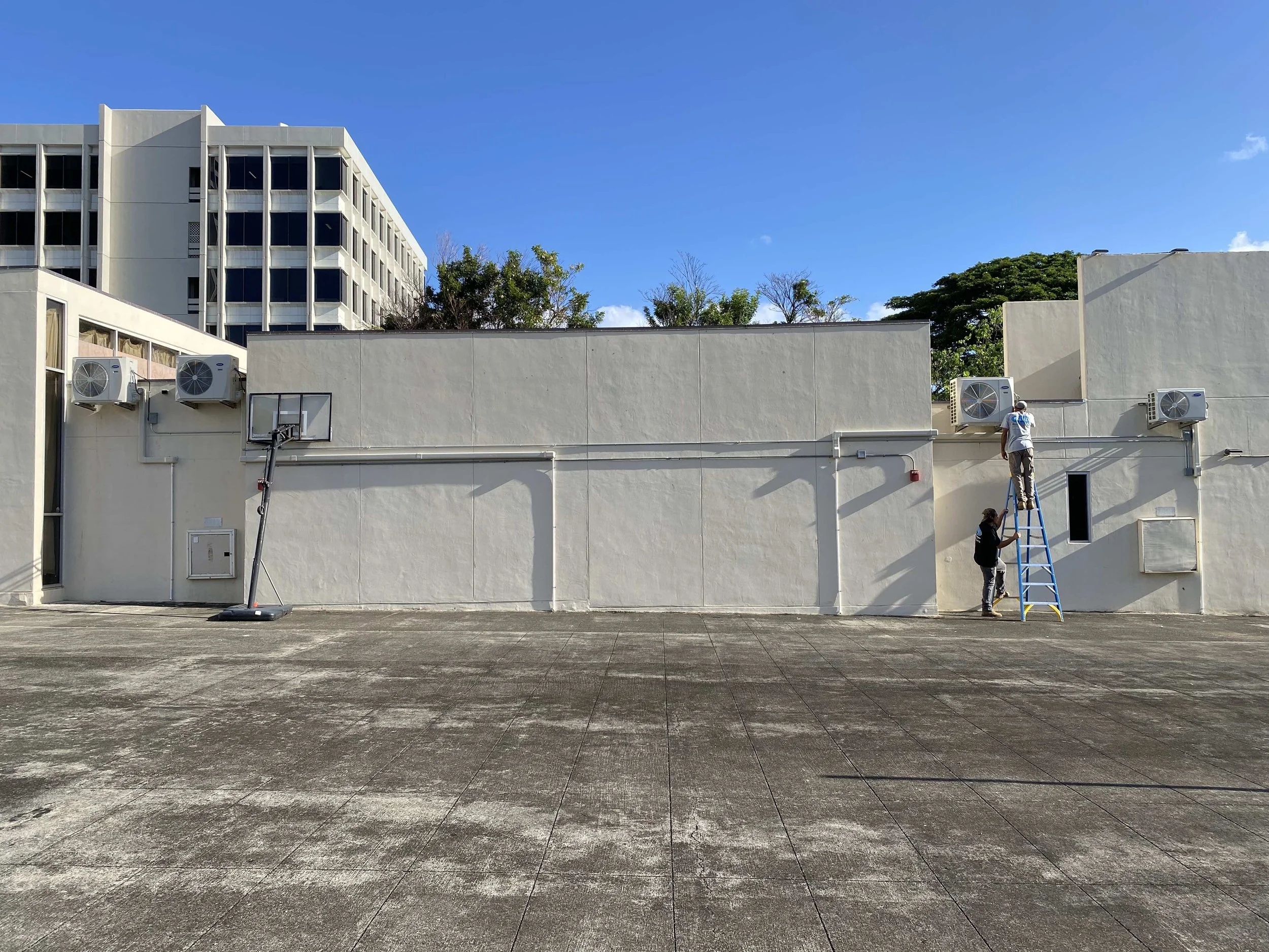 Zoomed out look at the four outdoor AC units on the rooftop.