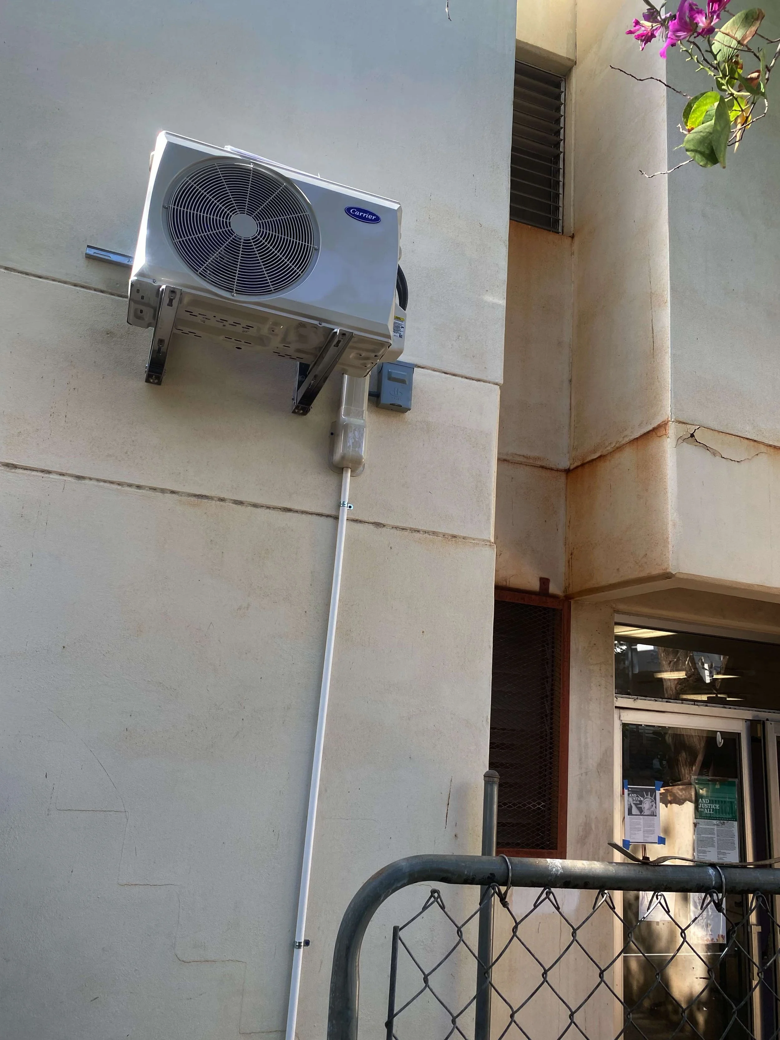 Outdoor AC unit mounted high on an exterior wall.