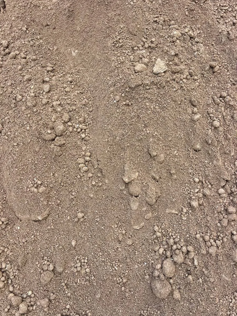 Close-up of sandy fill clay showing its fine soil texture, small clay clumps, and natural color variations.