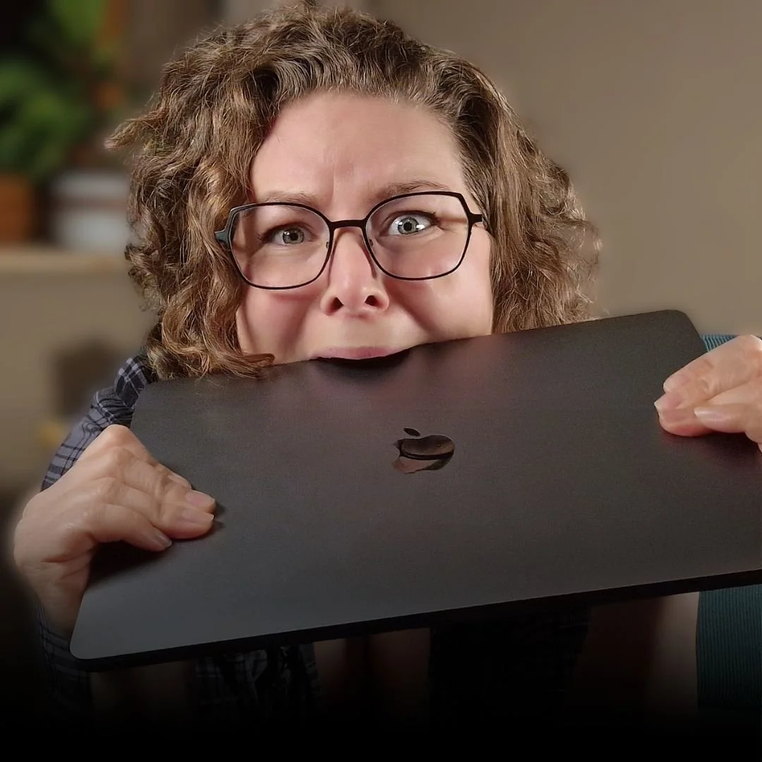 Person mit Brille hält einen Laptop mit einem angebissenen Logo.