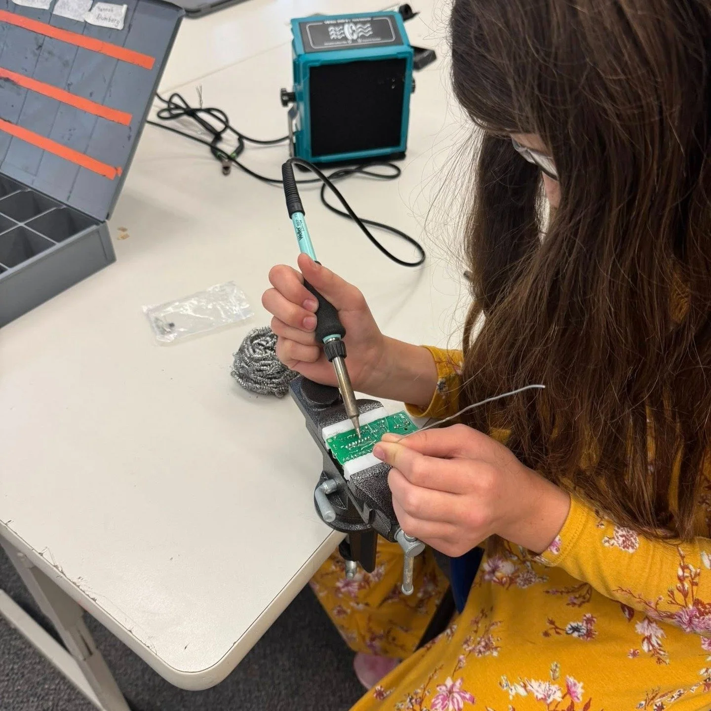 Students in the JMS Innovation lab solder motherboards to create their own light up acrylic name plate.