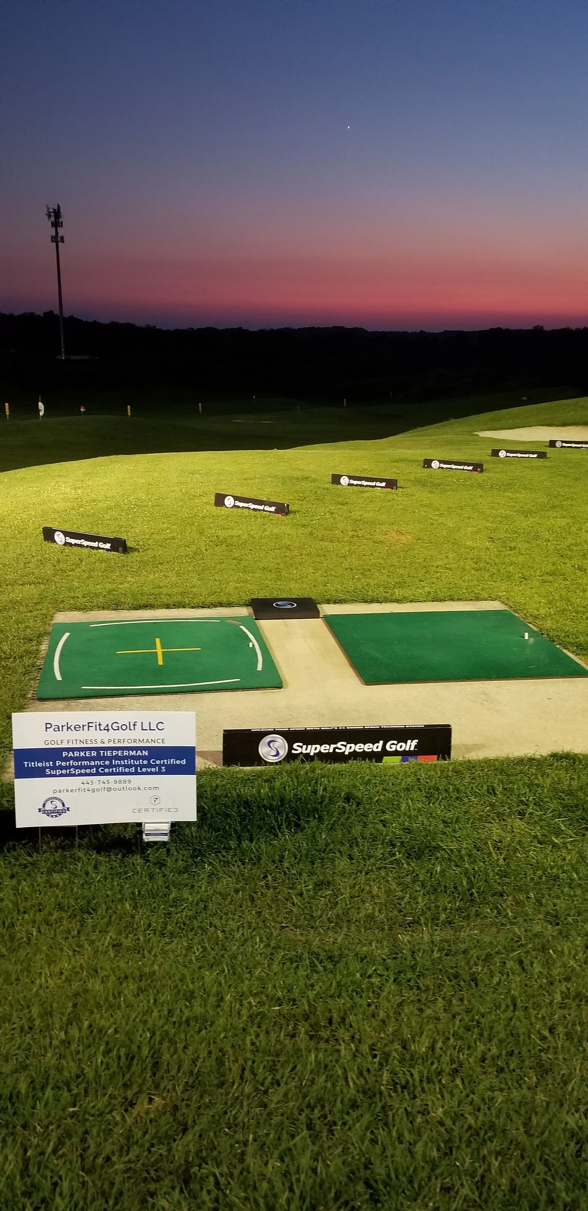 Golf training area at sunset with a mat labeled 'SuperSpeed Golf' and a sign for 'ParkerFit4Golf LLC.'