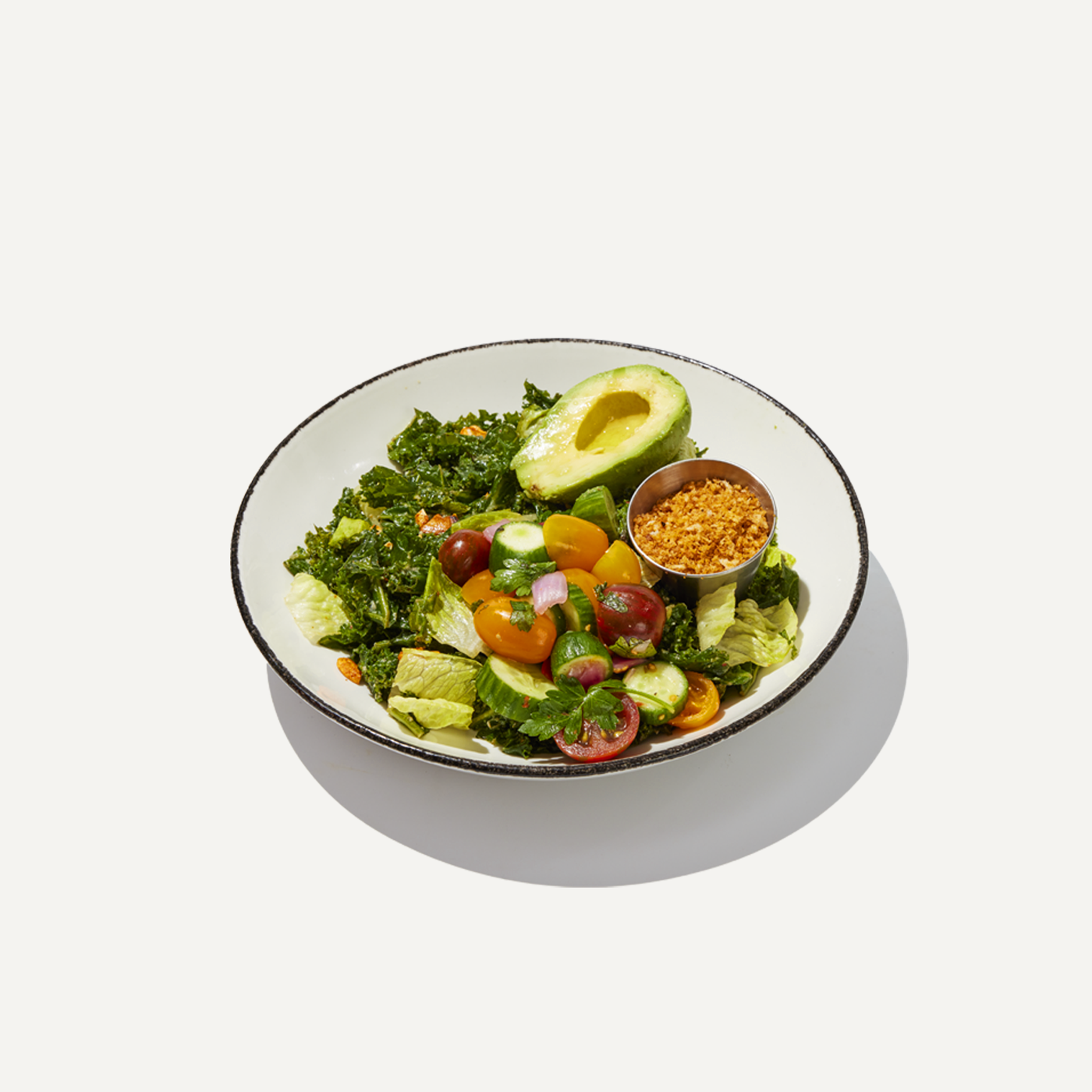 DIG Kale Caesar Salad with fresh vegetables, avocado, and crunchy topping.