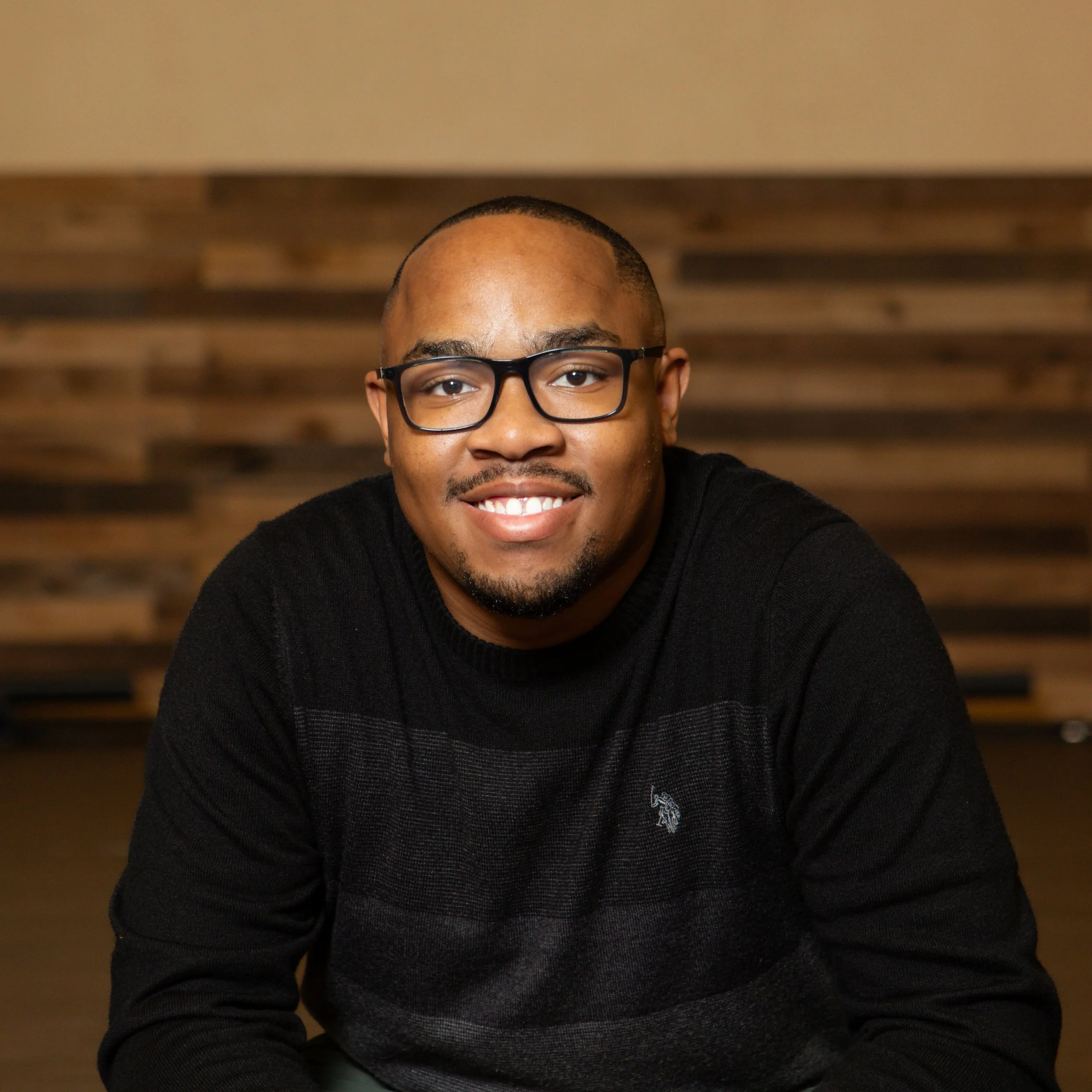 Isaiah sitting on stage, smiling