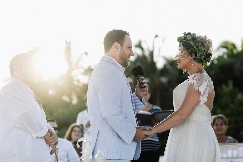 Destination Wedding couple holding hands during wedding vow on beach at Secrets Maroma, Riviera Maya, Mexico