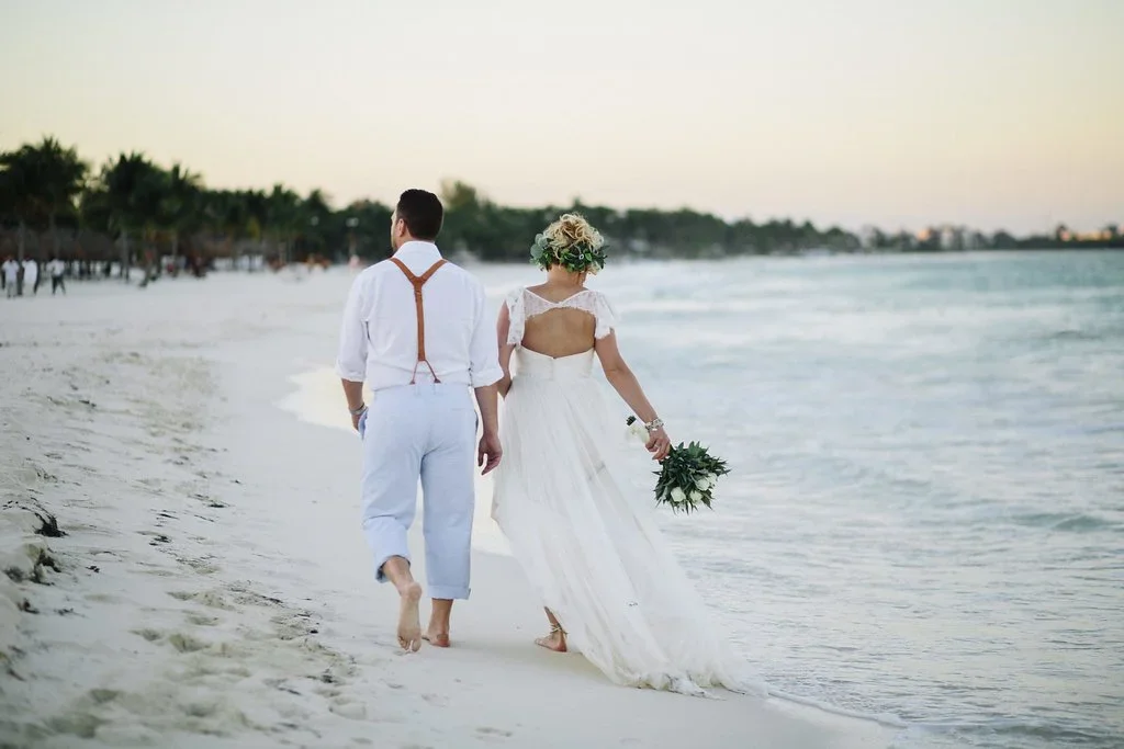 Newly married wedding couple walking the beach in Riviera Maya, Mexico