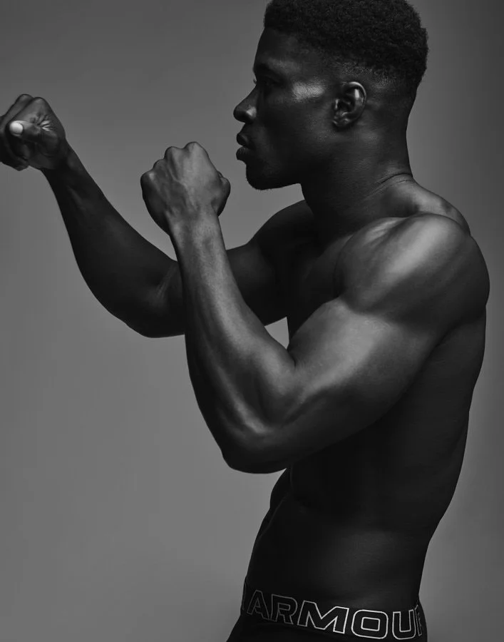 Shirtless boxer Kyle Hall shadowboxing in a studio, showcasing muscles and strength