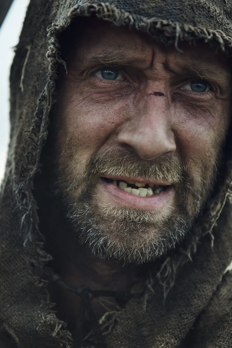 Close-up Portrait of a Weathered Medieval Warrior in Hooded Garment