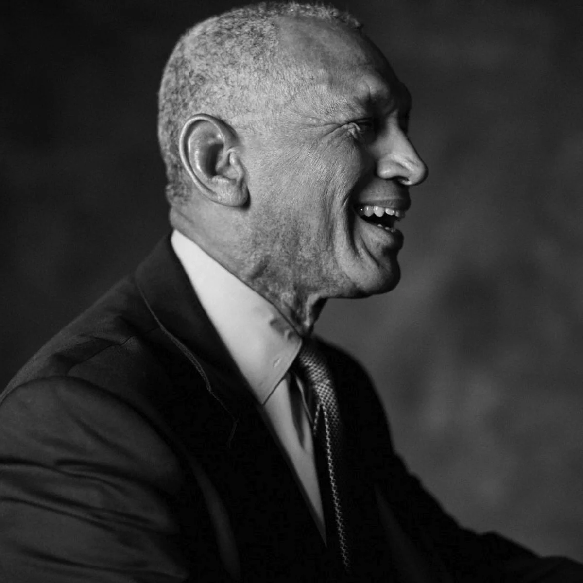Charles Bolden Jr. in a casual pose, smiling warmly in a dark jacket
