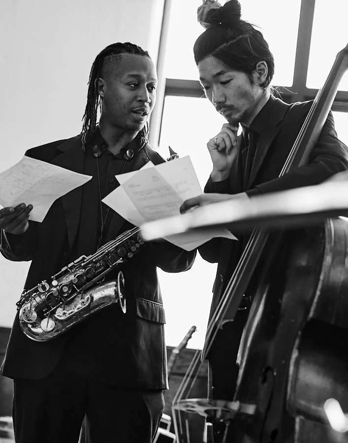 Two jazz musicians discussing sheet music during a rehearsal.