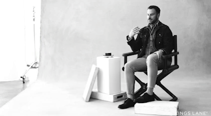 GIF of Ralph Lauren designer  in a candid interview setting, gesturing while seated