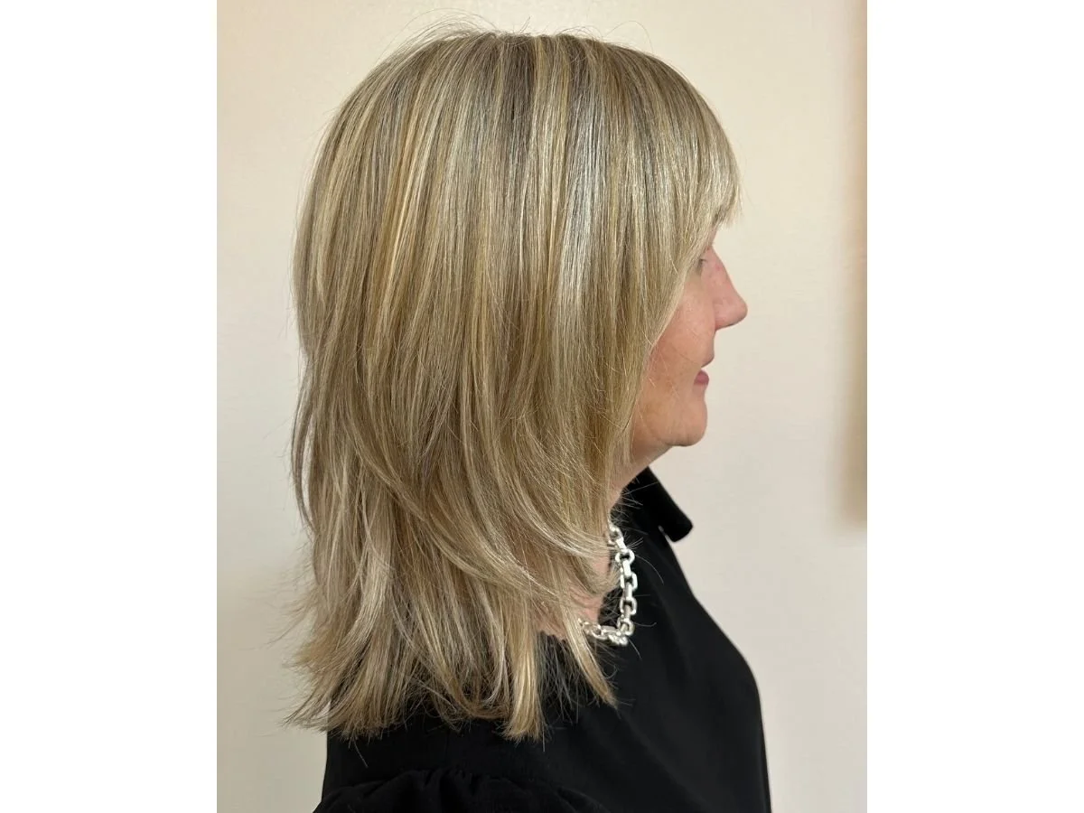 Woman with blonde highlights for gray blending for a natural grow out.