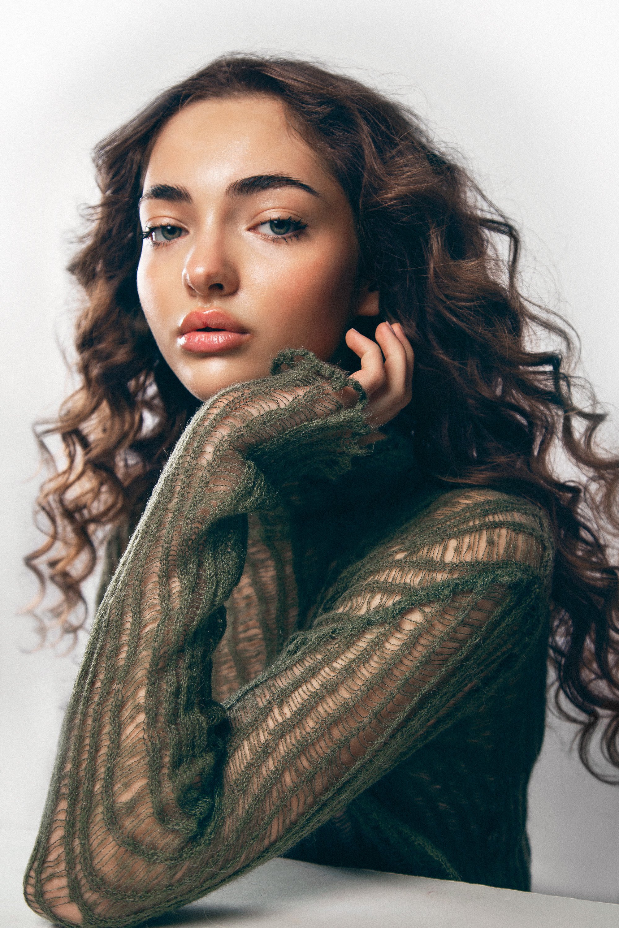 Shooting beauté dans un studio parisien avec la photographe Charlène Grimaud, mettant en avant un look sophistiqué. La coiffure, signée Maxime Guicheteau, crée un effet mouillé élégant