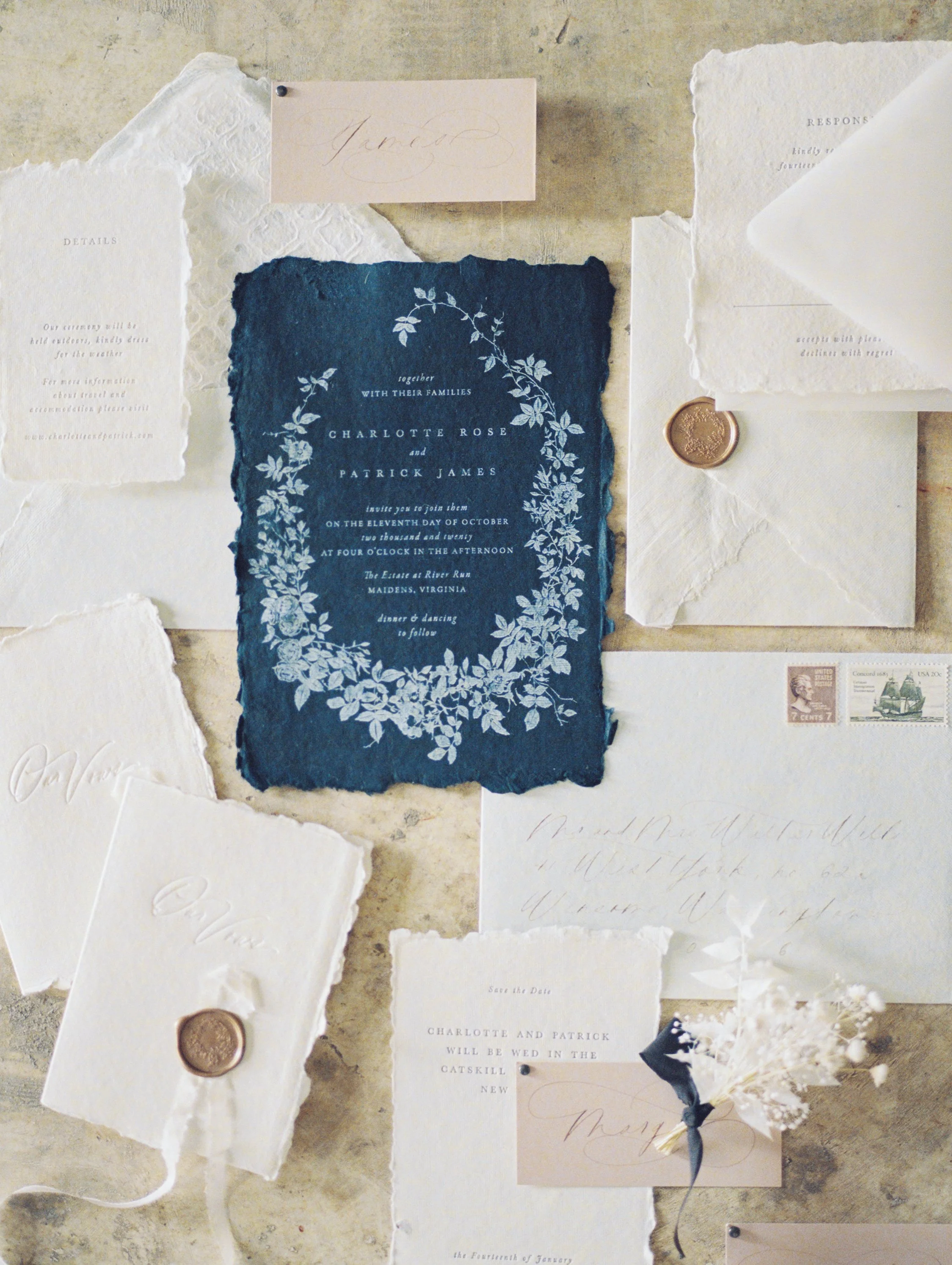 Fine-art wedding invitation flat lay featuring handmade paper, embossed details, and wax seals, styled by The Petaler Floral & Events Co., a luxury wedding planner and floral designer for American couples hosting destination weddings in France.