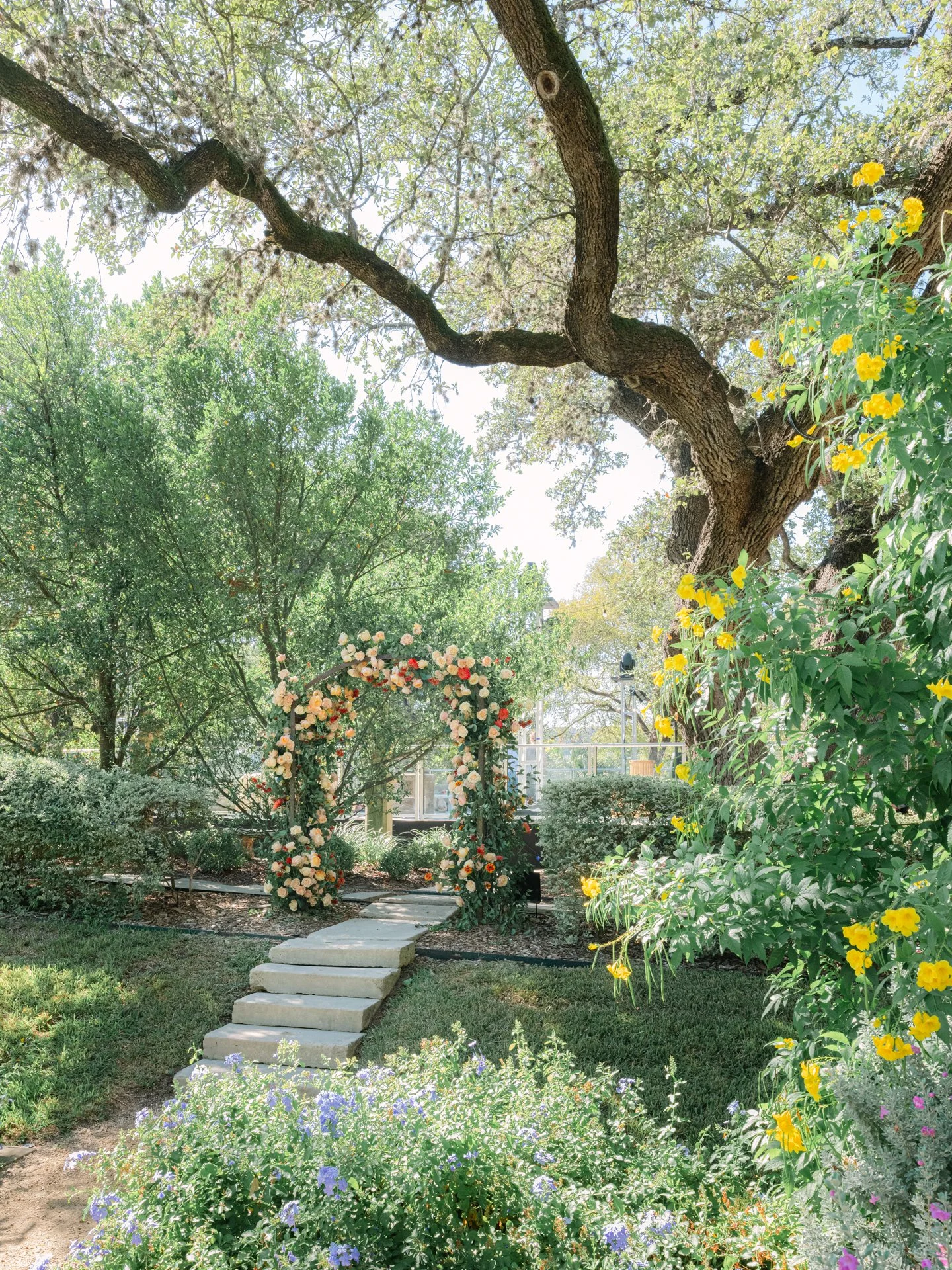 ColorfulLuxury outdoor wedding floral arch at the Austin Contemporary with roses, greenery, and romantic garden design rose arch