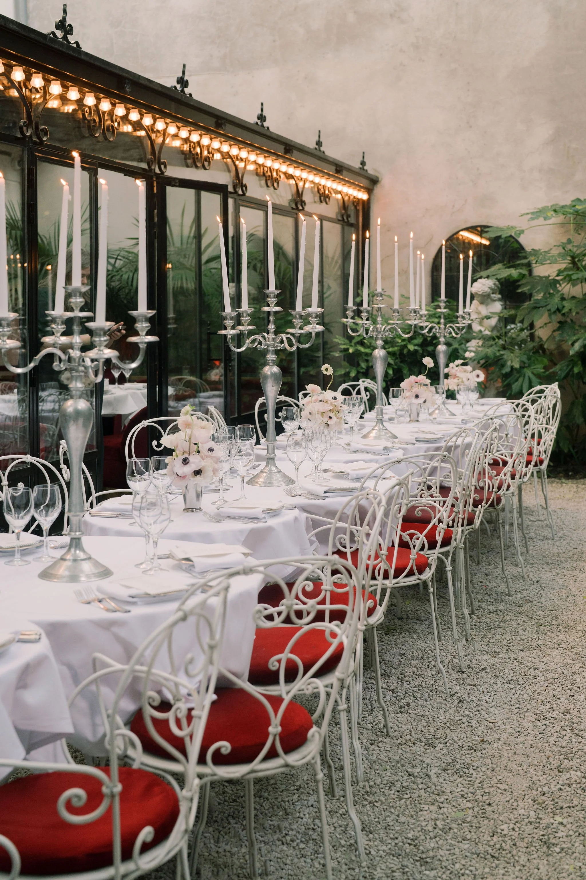Elegant outdoor reception table set with tall silver candelabras, airy pastel florals at Hôtel Particulier en Montmartre. Wedding production by The Petaler Floral & Events Co. destination wedding planners for Americans in France.