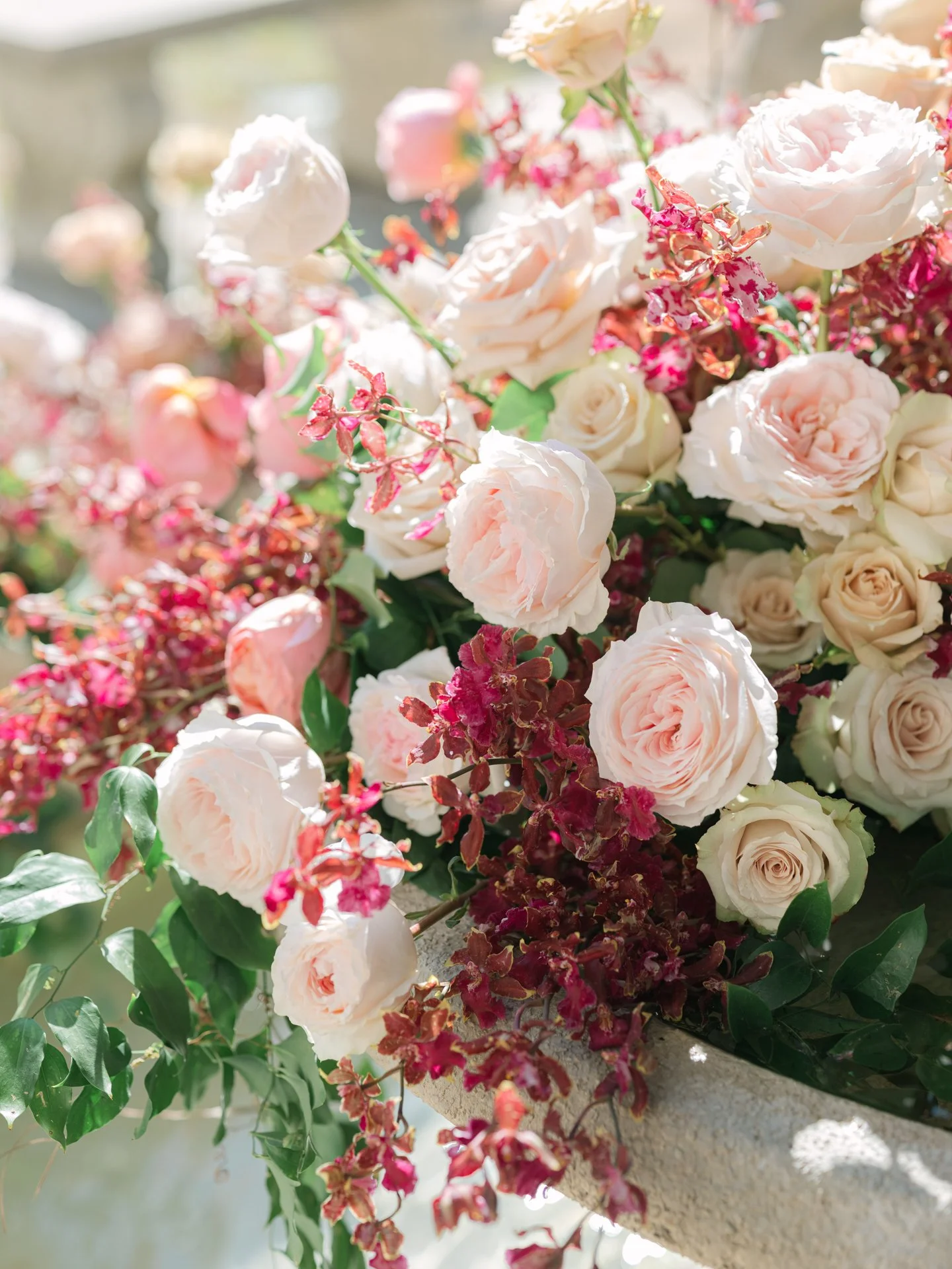 Close up image of peach Rosies and shari baby orchids arranged on the fountain at the Contemporary Austin