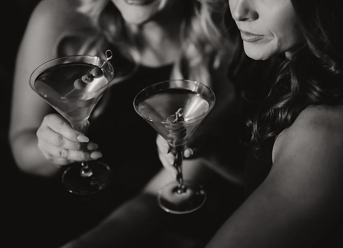 Black and white photograph of wedding guests holding martini glasses during cocktail hour