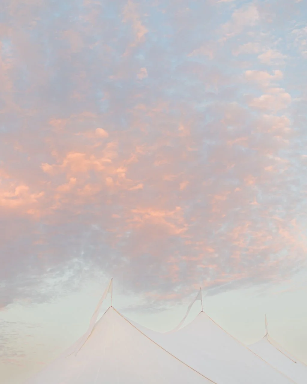 Soft pastel sunset above a white sailcloth tent along the Texas coast, captured during Allie and Matt’s southern wedding celebration. Design by The Petaler Floral and Events Co.