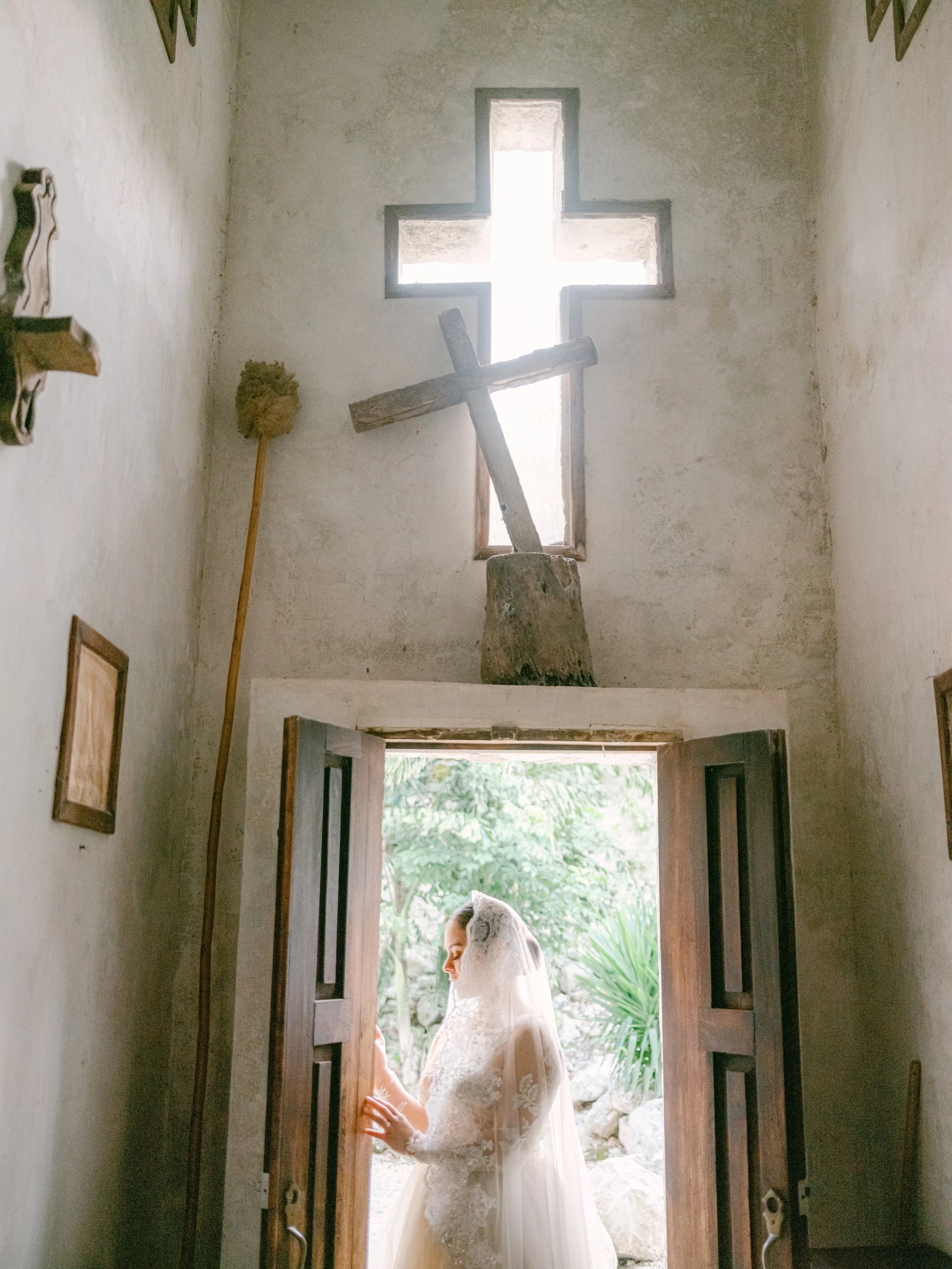 Softly lit bridal portrait at the chapel entrance of Coqui Coqui Coba, embodying the intimate, old-world romance and elevated design sensibility of a luxury wedding planner serving American couples seeking refined destination weddings in Mexico