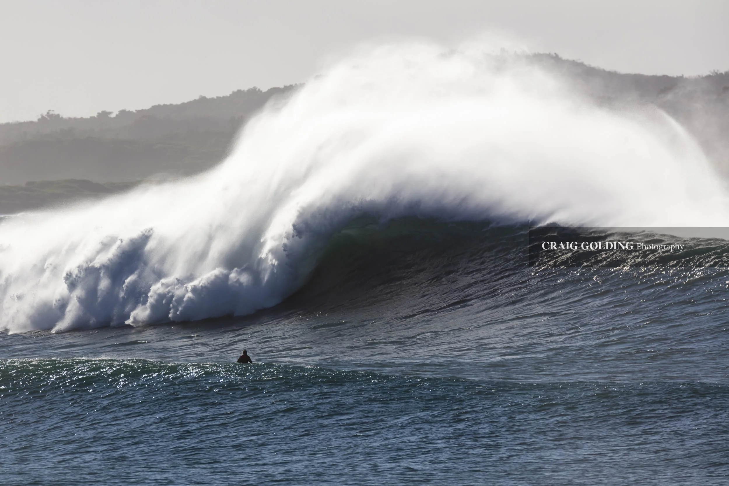 Wanda surfer watches wave.
