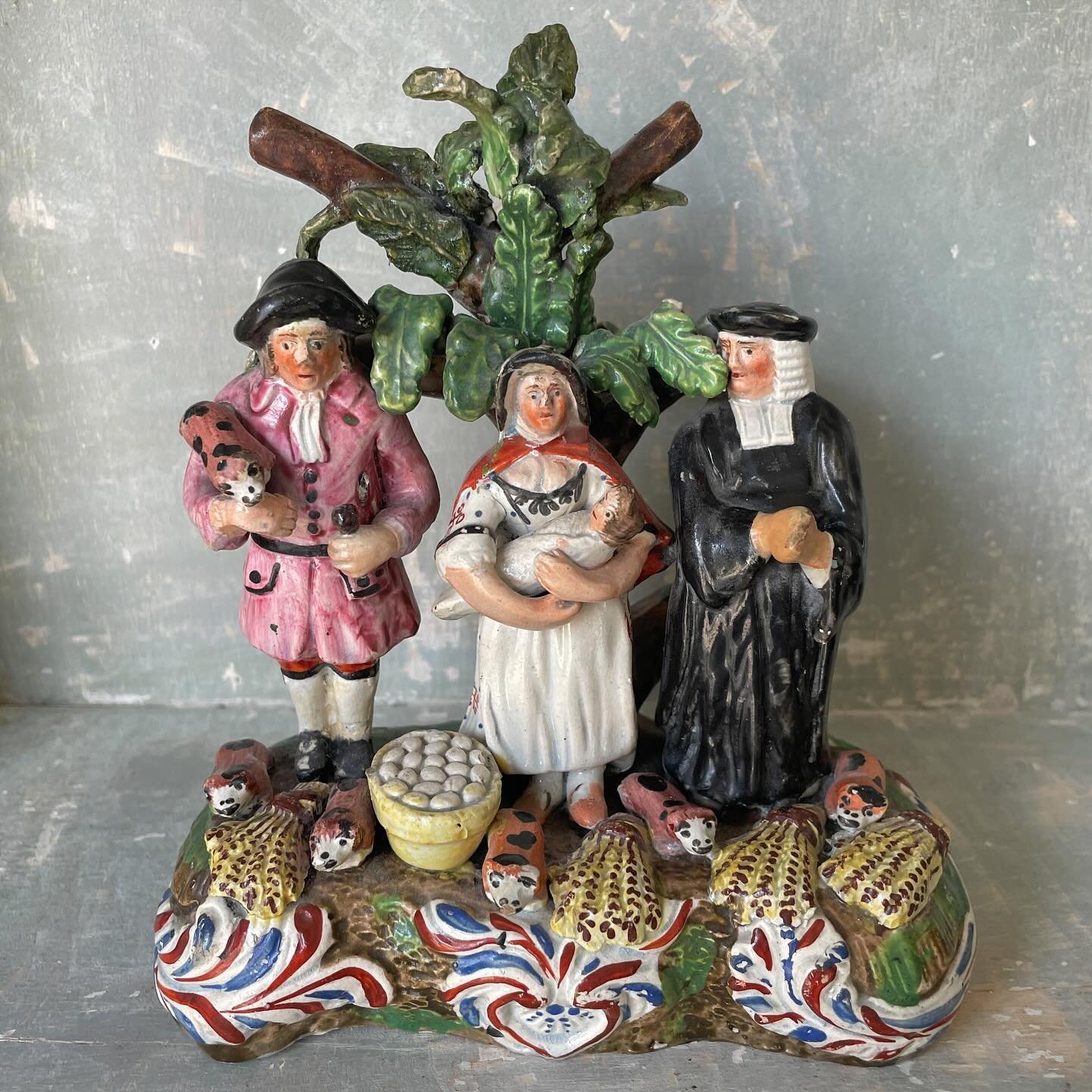 FOR SALE A particularly appealing and colourful example of &lsquo;The Tithe Pig&rsquo;, circa 1830. It is a well known Staffordshire pottery figure depicting a farmer holding a pig, his wife with babe in arms and a clergyman. It is a very amusing sce