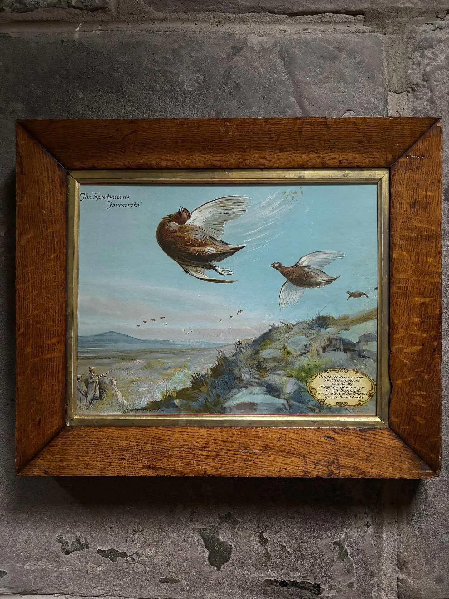 FOR SALE A magnificent early Famous Grouse trade card print entitled &rsquo;The Sportsman&rsquo;s Favourite&rsquo;, circa 1920. Framed in a superb antique oak frame with gilt slip. 

It is a rare example of early advertising for the famous whisky bra