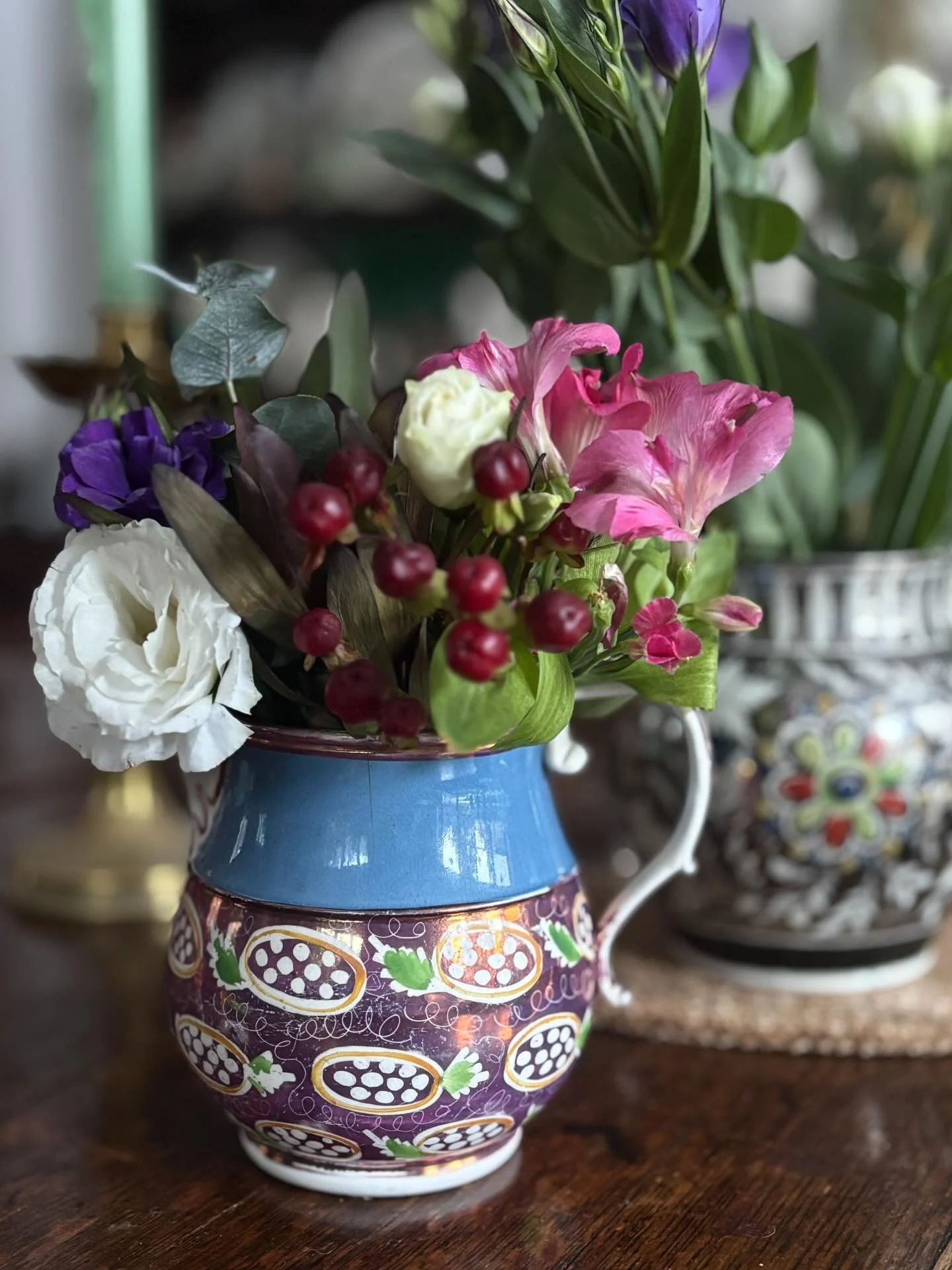 FOR SALE A striking early to mid 19th century pink lustre jug with blue band. The body of the jug features stylised berries with green leaves surrounded by hand etched meandering white swirls. The beautiful handle is handsomely decorated in pink lust