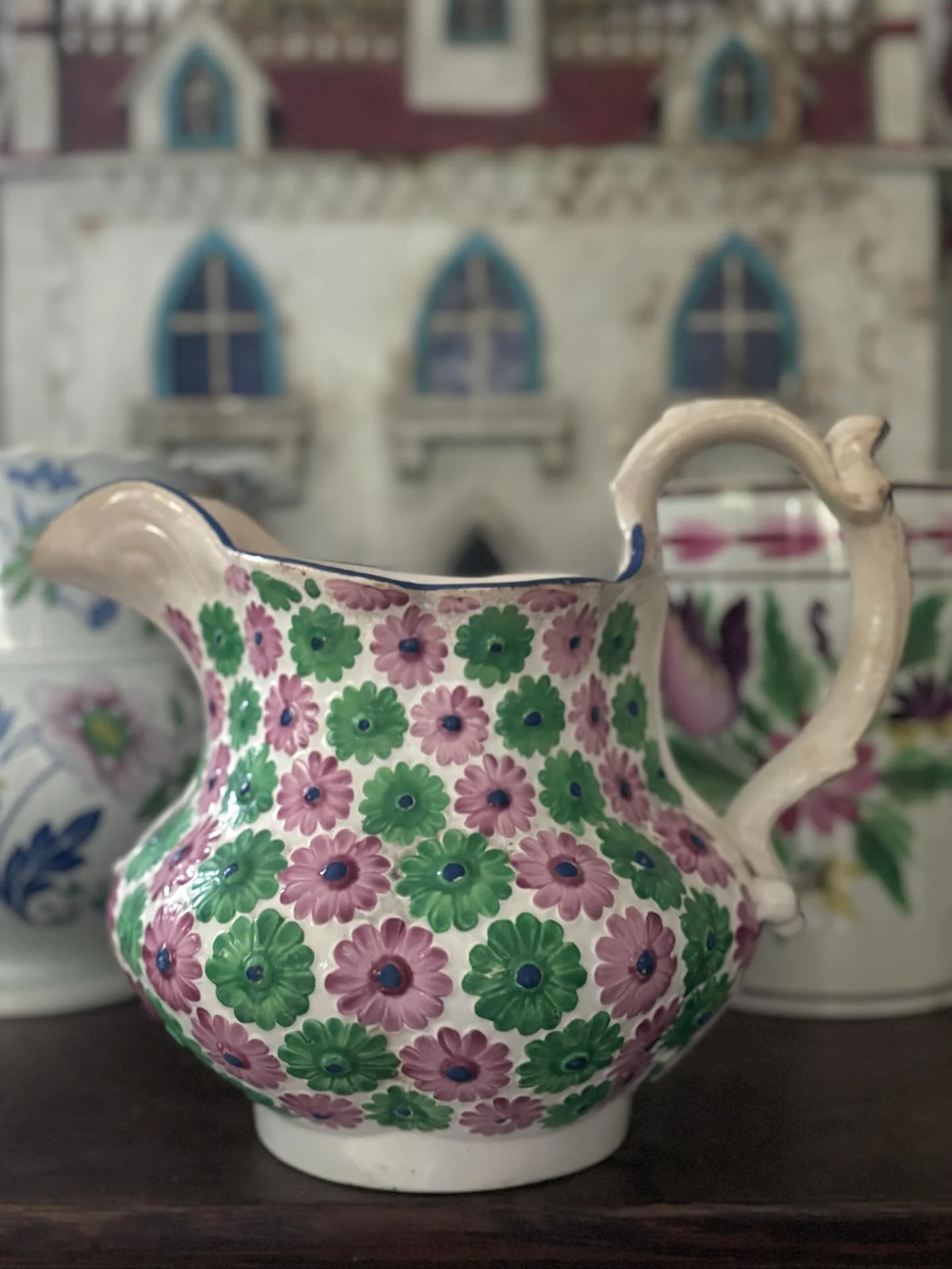 SOLD 🌟 A superb and very unusual 19th century earthenware jug decorated with moulded green and pink flowers. It has a splendid handle, the design accentuated with dark blue markings. 

It is in very good condition. There is crazing with resulting di