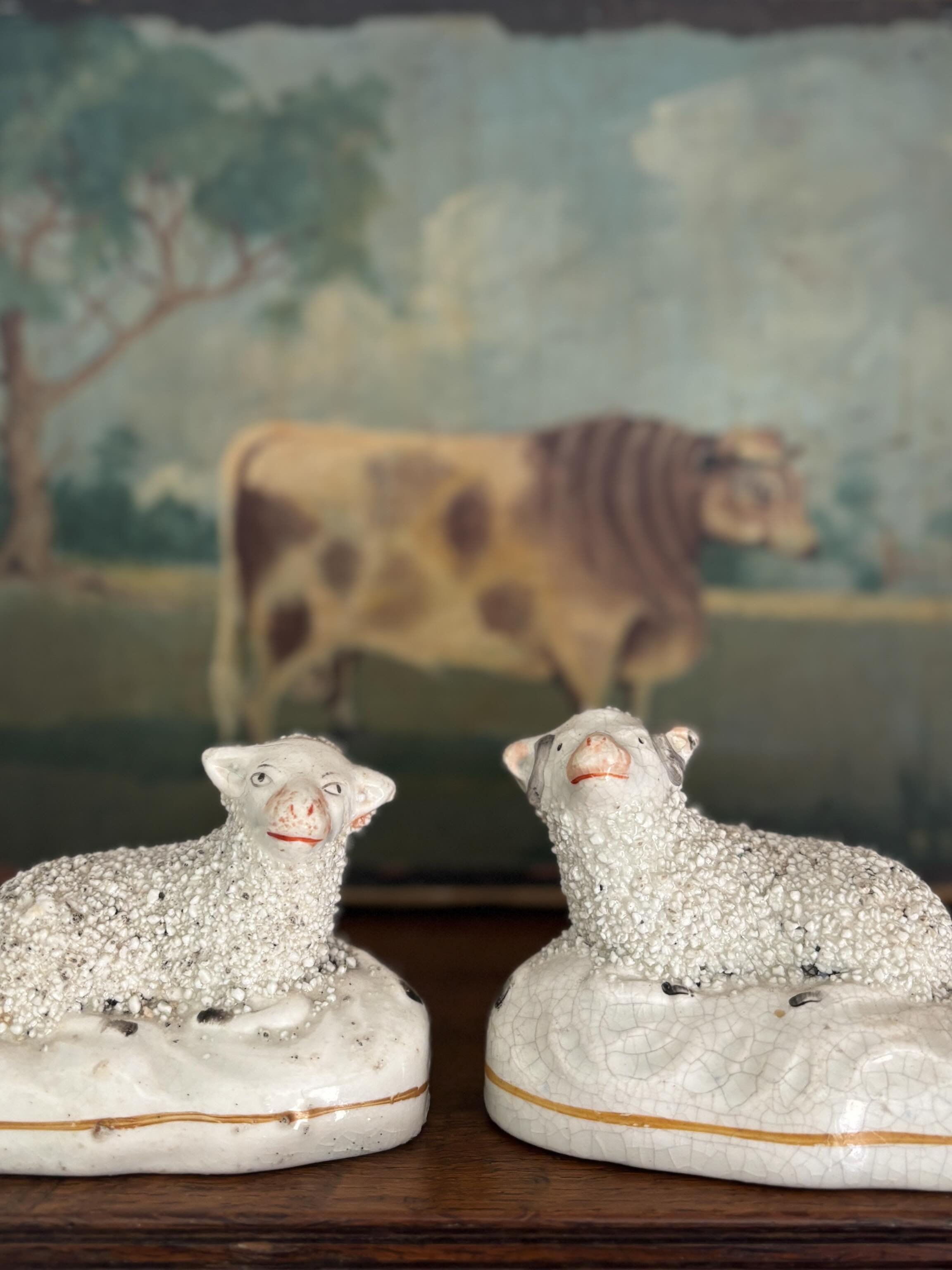 PENDING An enchanting pair of antique miniature Staffordshire sheep, circa 1850 - a ewe and a ram, both with the most adorable expressions on their faces, so characteristic of such Staffordshire figures. Lovely textured fleeces, both sheep recumbent 